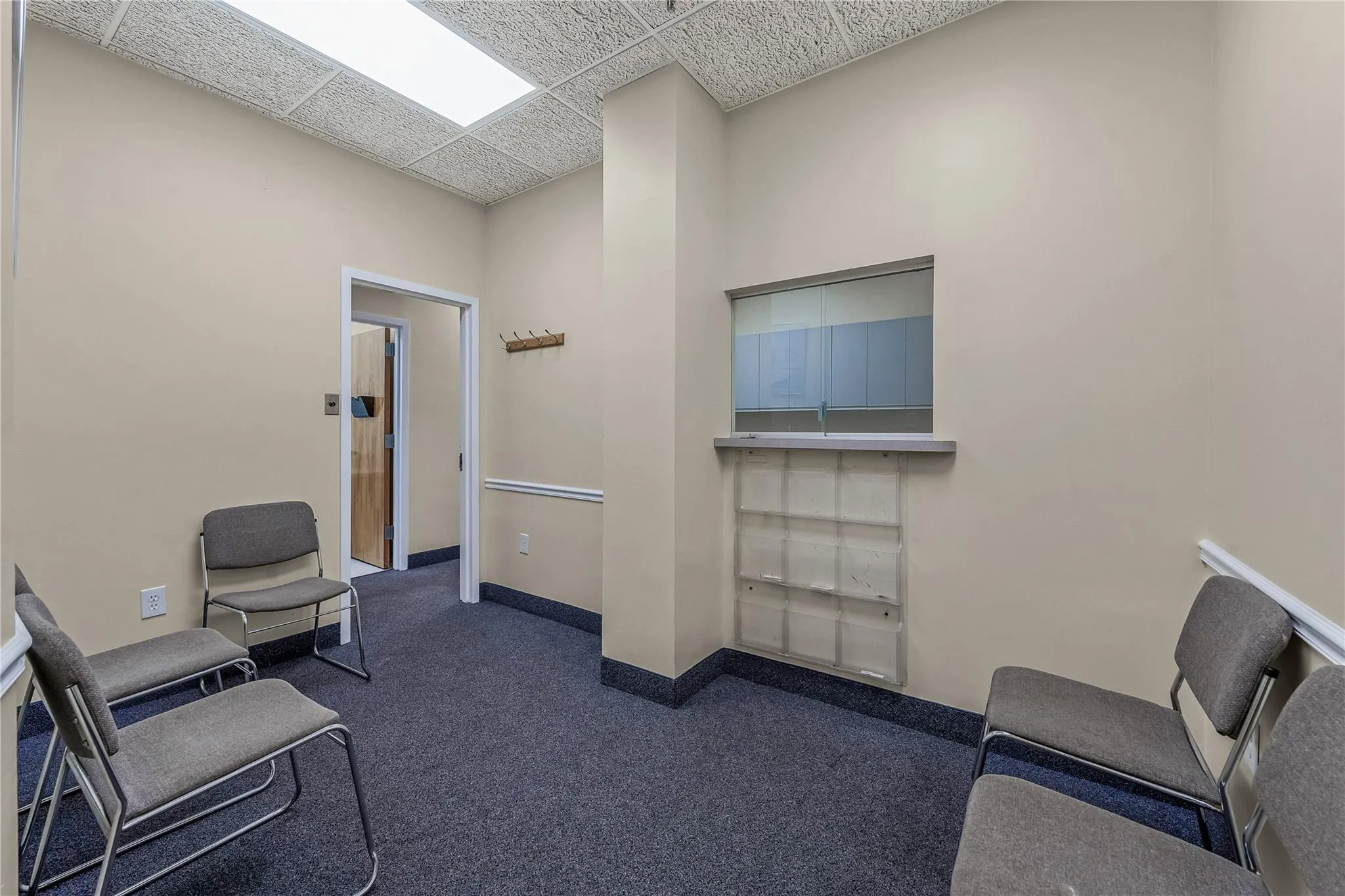Sitting room with dark colored carpet and a paneled ceiling Sitting room with dark colored carpet and a paneled ceiling