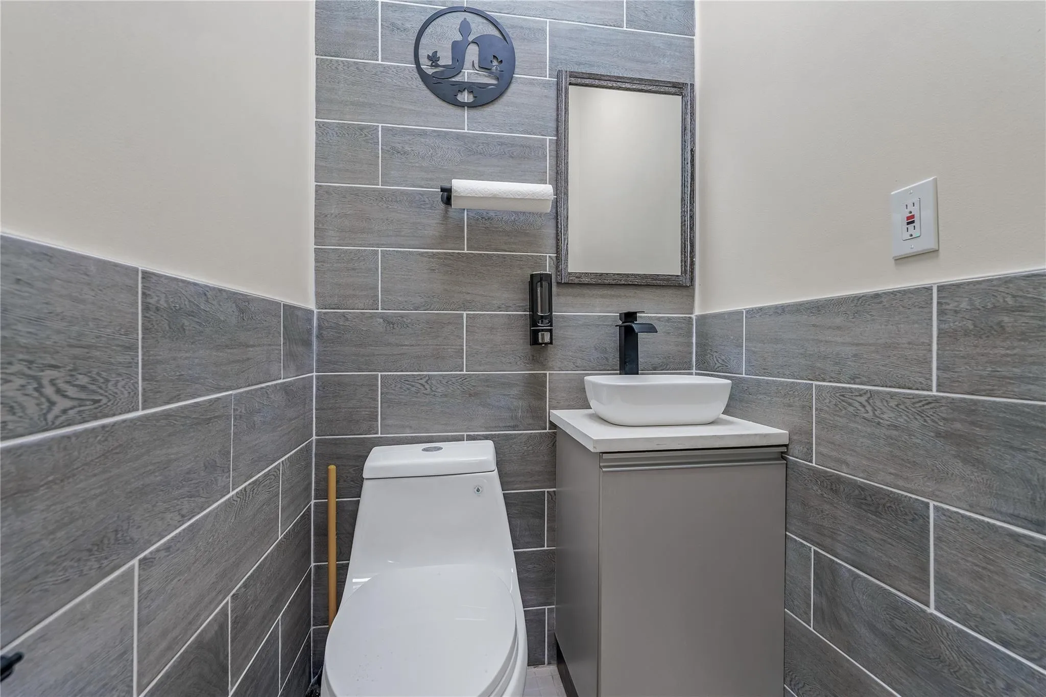 Bathroom featuring tile walls, vanity, and wainscoting Bathroom featuring tile walls, vanity, and wainscoting