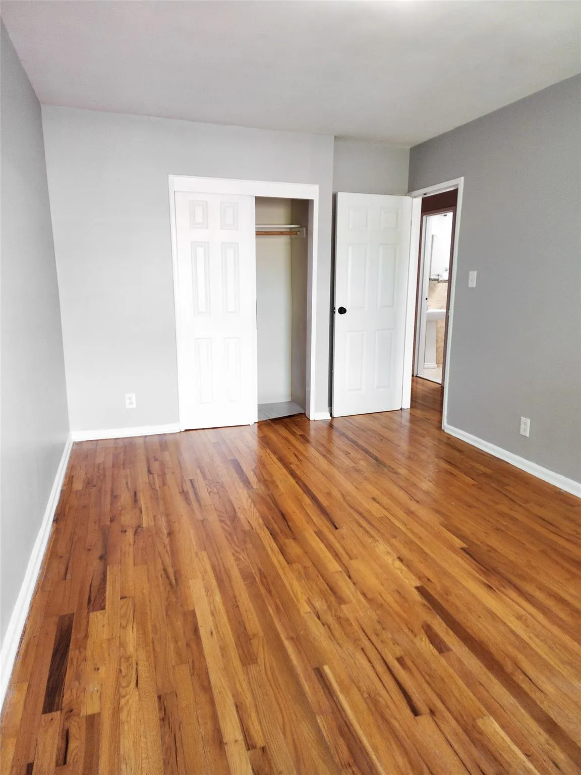 Unfurnished bedroom with wood finished floors and a closet Unfurnished bedroom with wood finished floors and a closet