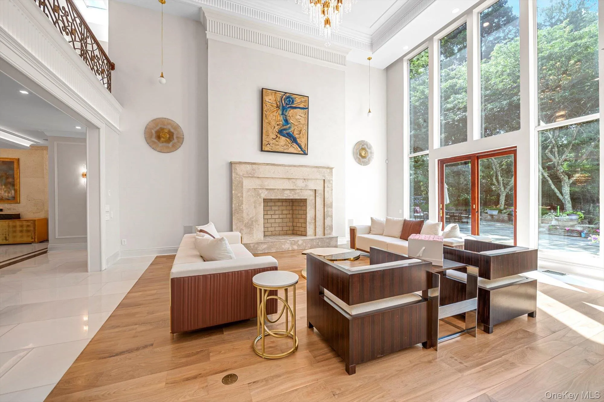 Living room with a towering ceiling, ornamental molding, a fireplace, and light wood-type flooring Living room with a towering ceiling, ornamental molding, a fireplace, and light wood-type flooring