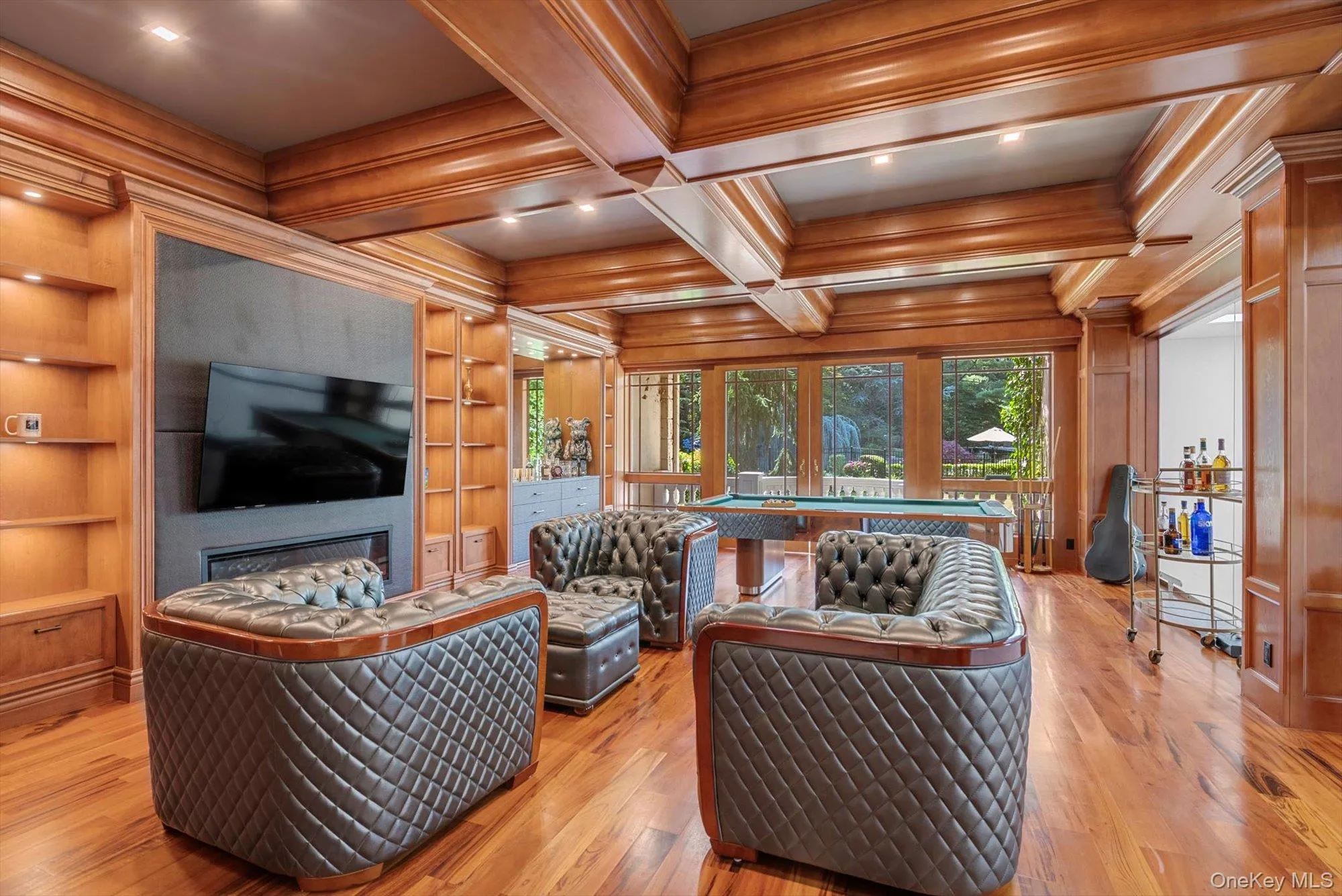 Living room with ornamental molding, built in features, coffered ceiling, light wood-style flooring, and beamed ceiling Living room with ornamental molding, built in features, coffered ceiling, light wood-style flooring, and beamed ceiling