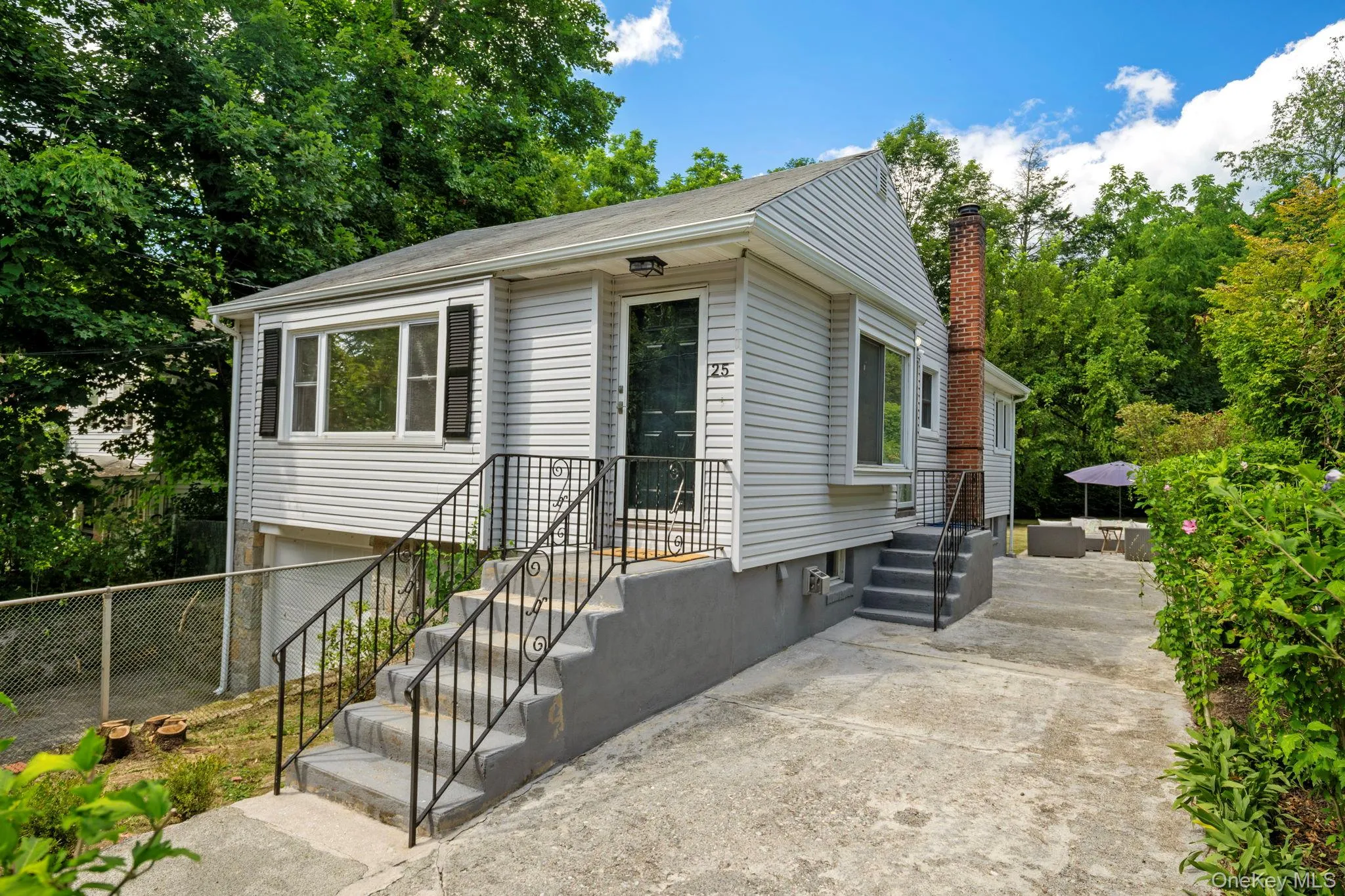 View of front facade with a chimney and a patio View of front facade with a chimney and a patio