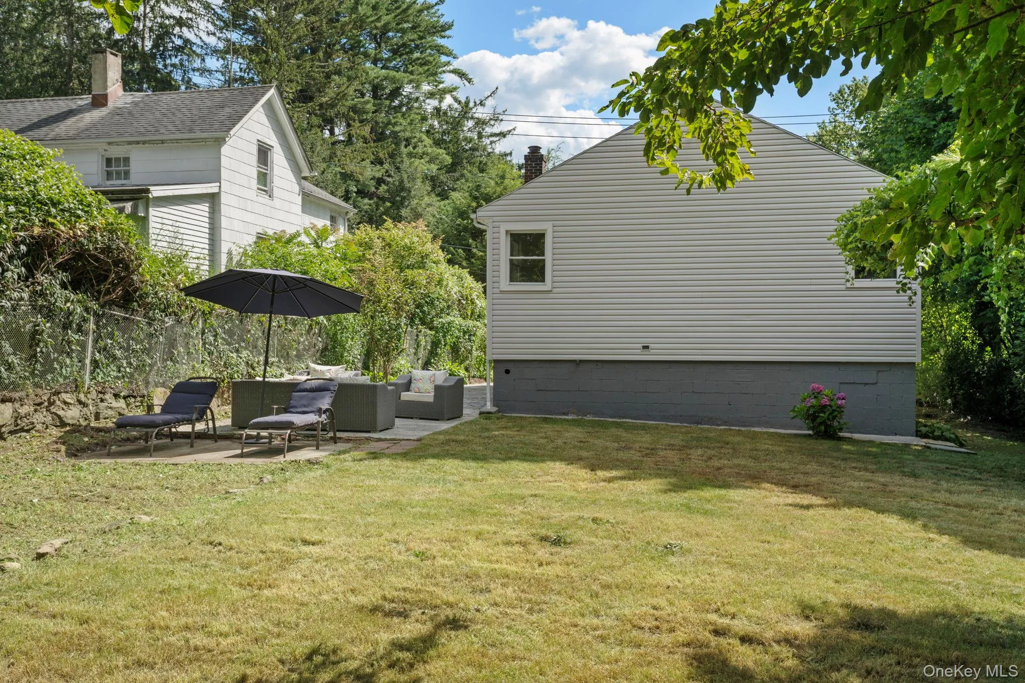 View of grassy yard featuring an outdoor hangout area and a patio area View of grassy yard featuring an outdoor hangout area and a patio area