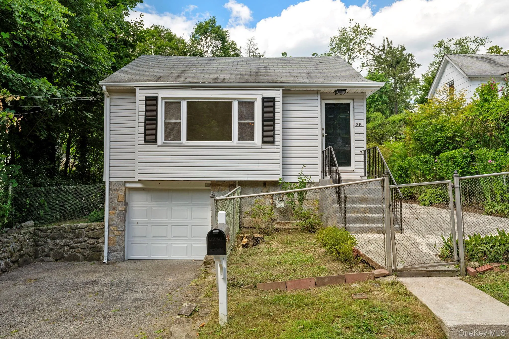 View of front facade featuring a gate, a garage, a fenced front yard, and driveway View of front facade featuring a gate, a garage, a fenced front yard, and driveway