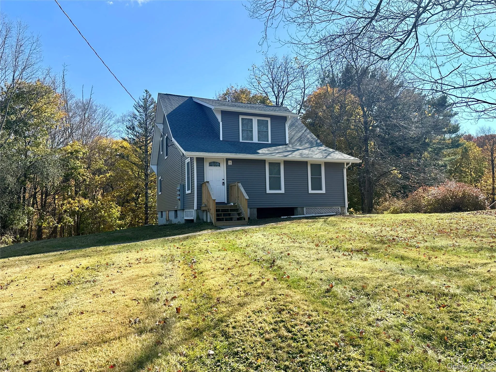View of front of house featuring a front lawn and a shingled roof View of front of house featuring a front lawn and a shingled roof