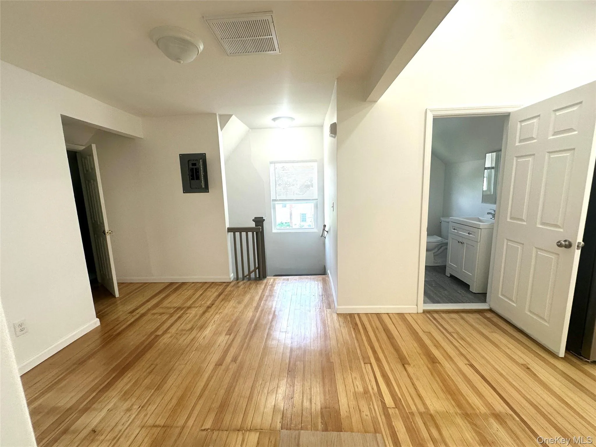Unfurnished room with light wood-style floors and electric panel Unfurnished room with light wood-style floors and electric panel