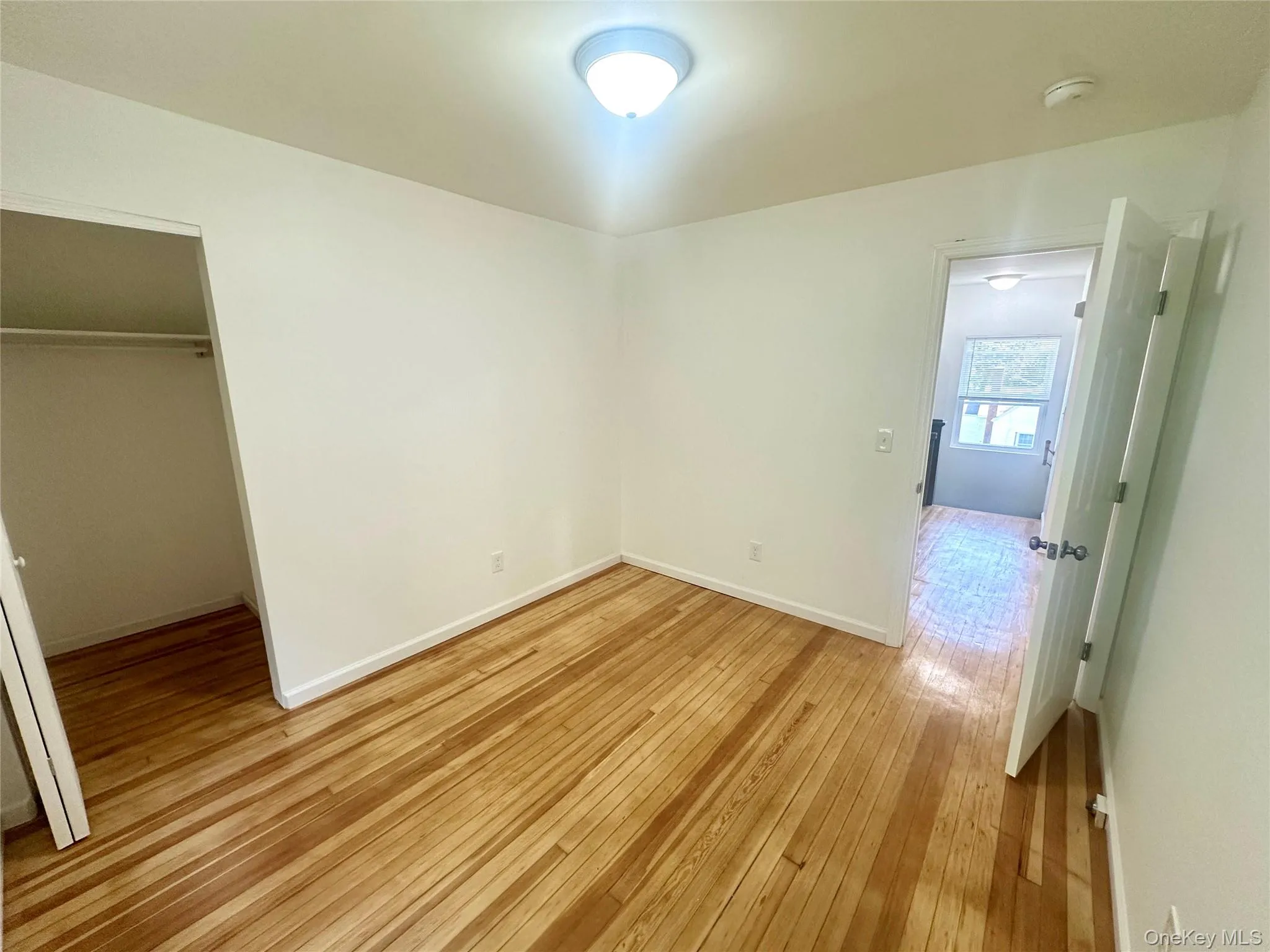 Unfurnished bedroom featuring light wood-type flooring and a closet Unfurnished bedroom featuring light wood-type flooring and a closet