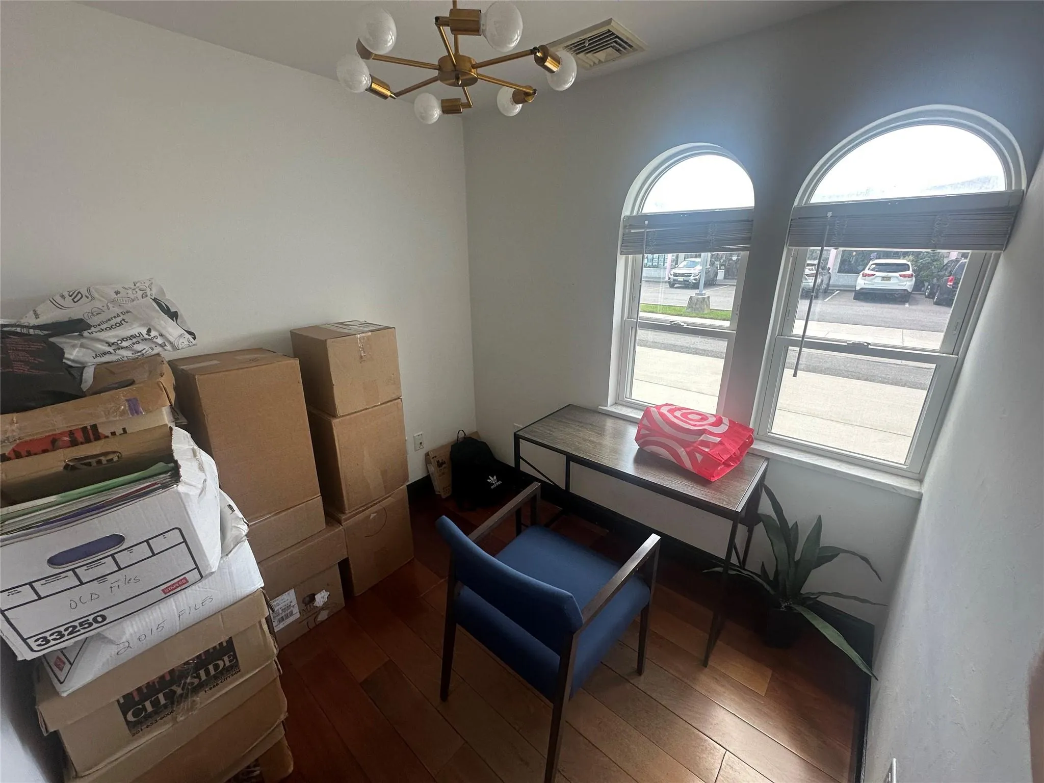 Office with a chandelier and wood finished floors Office with a chandelier and wood finished floors