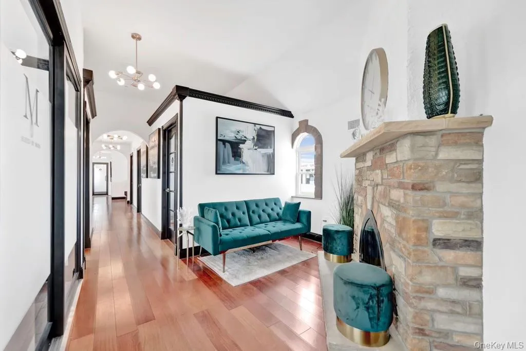 Hallway with vaulted ceiling, a chandelier, light wood-style floors, and arched walkways Hallway with vaulted ceiling, a chandelier, light wood-style floors, and arched walkways
