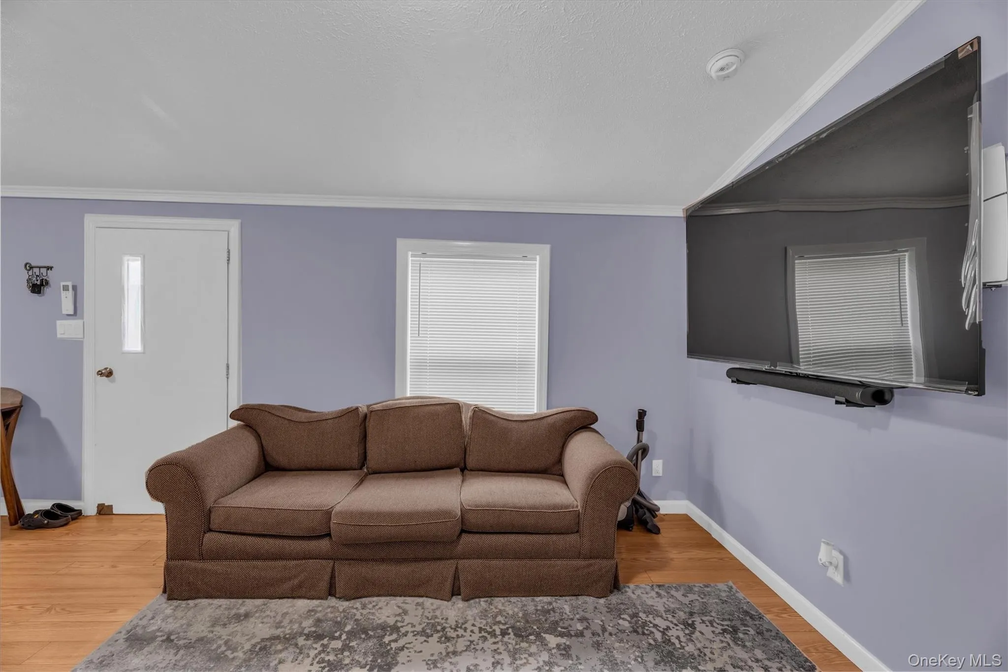 Living area featuring crown molding and wood finished floors Living area featuring crown molding and wood finished floors