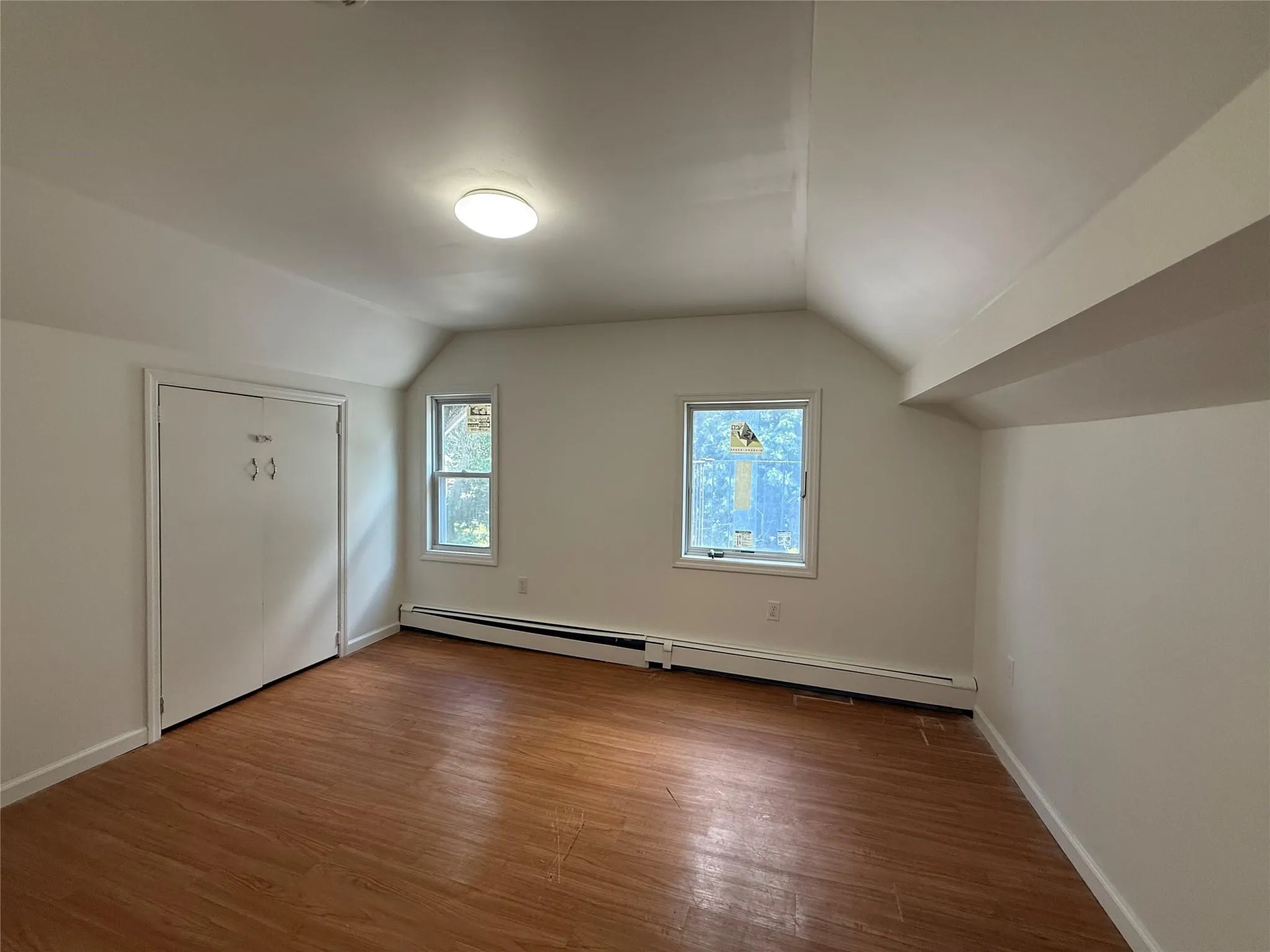 Bonus room featuring wood finished floors, baseboard heating, and lofted ceiling Bonus room featuring wood finished floors, baseboard heating, and lofted ceiling