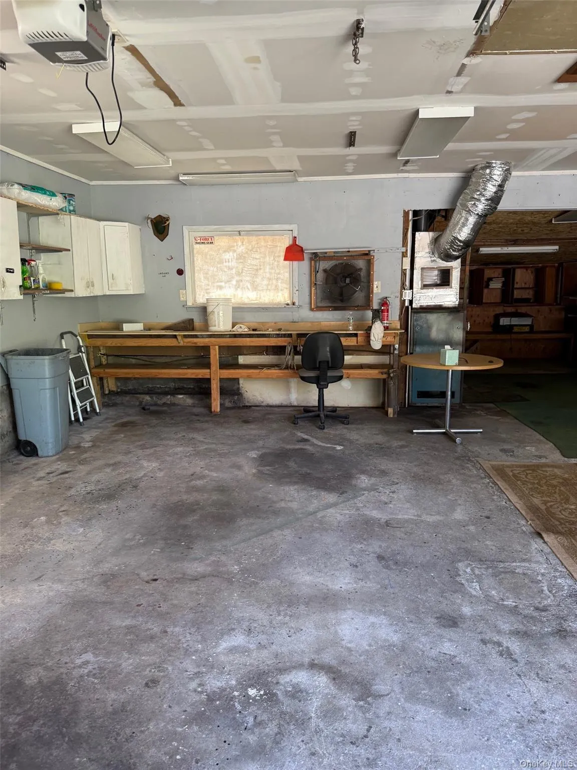Garage featuring a workshop area and a garage door opener Garage featuring a workshop area and a garage door opener