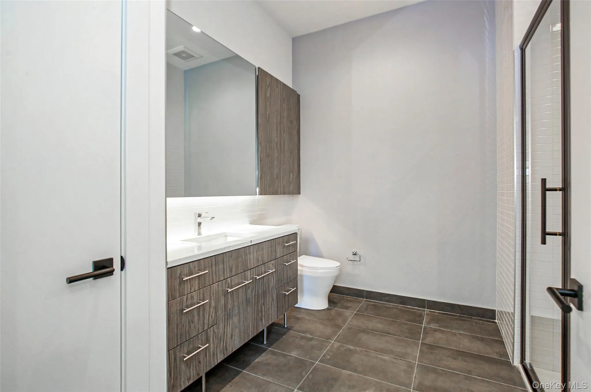 Bathroom with vanity, tile patterned floors, a shower stall, and recessed lighting Bathroom with vanity, tile patterned floors, a shower stall, and recessed lighting
