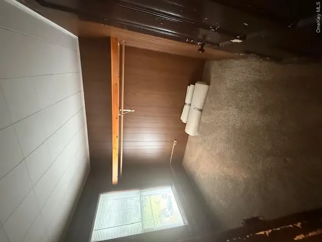 Carpeted room featuring wood-finish wall panels and a drop ceiling Carpeted room featuring wood-finish wall panels and a drop ceiling