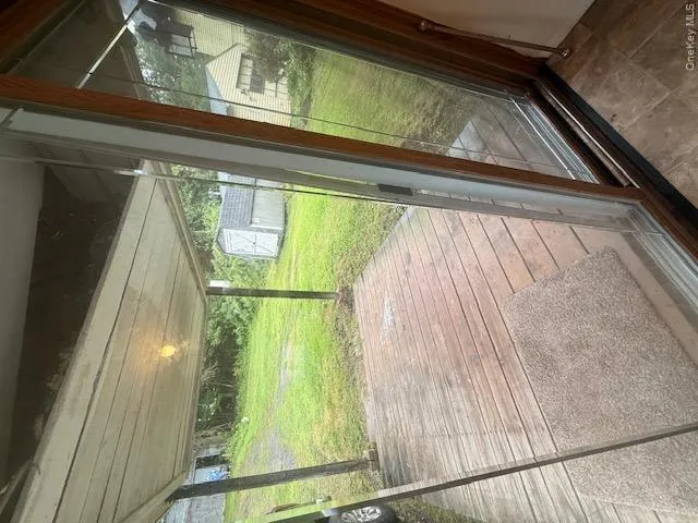 Sliding glass door opening to a covered wooden deck Sliding glass door opening to a covered wooden deck