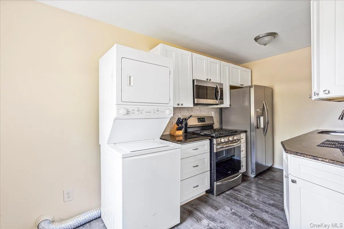 Kitchen featuring stacked washer / dryer, appliances with stainless steel finishes Kitchen featuring stacked washer / dryer, appliances with stainless steel finishes
