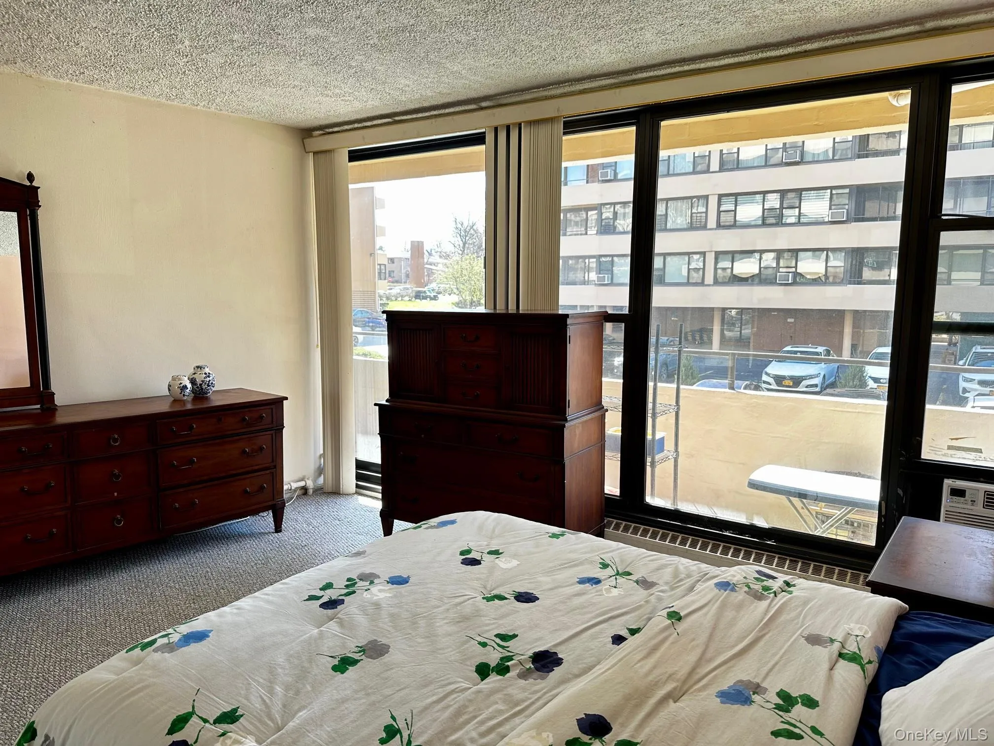 Carpeted bedroom featuring a textured ceiling and access to exterior Carpeted bedroom featuring a textured ceiling and access to exterior