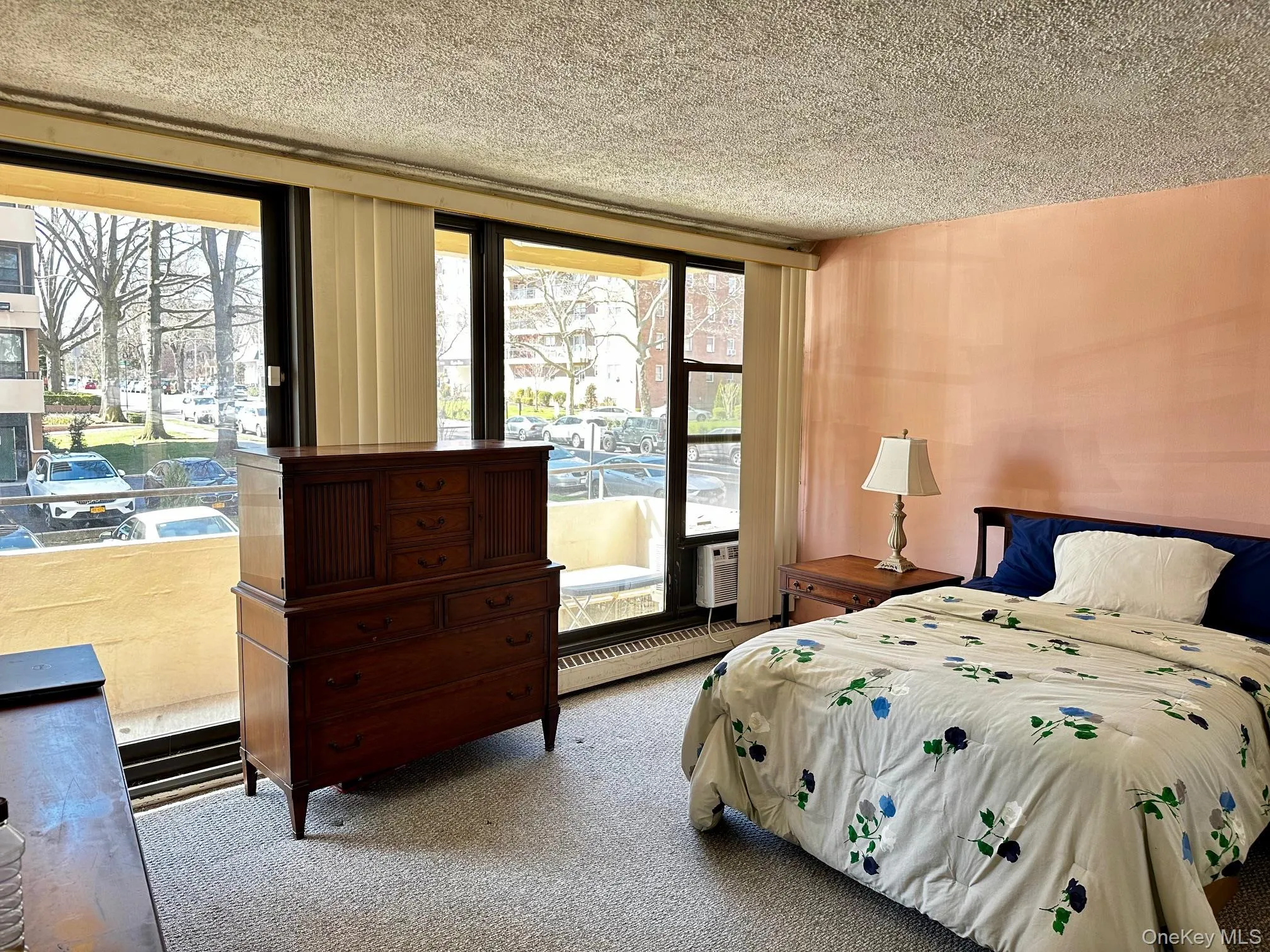 Bedroom with carpet, a textured ceiling, and access to outside Bedroom with carpet, a textured ceiling, and access to outside