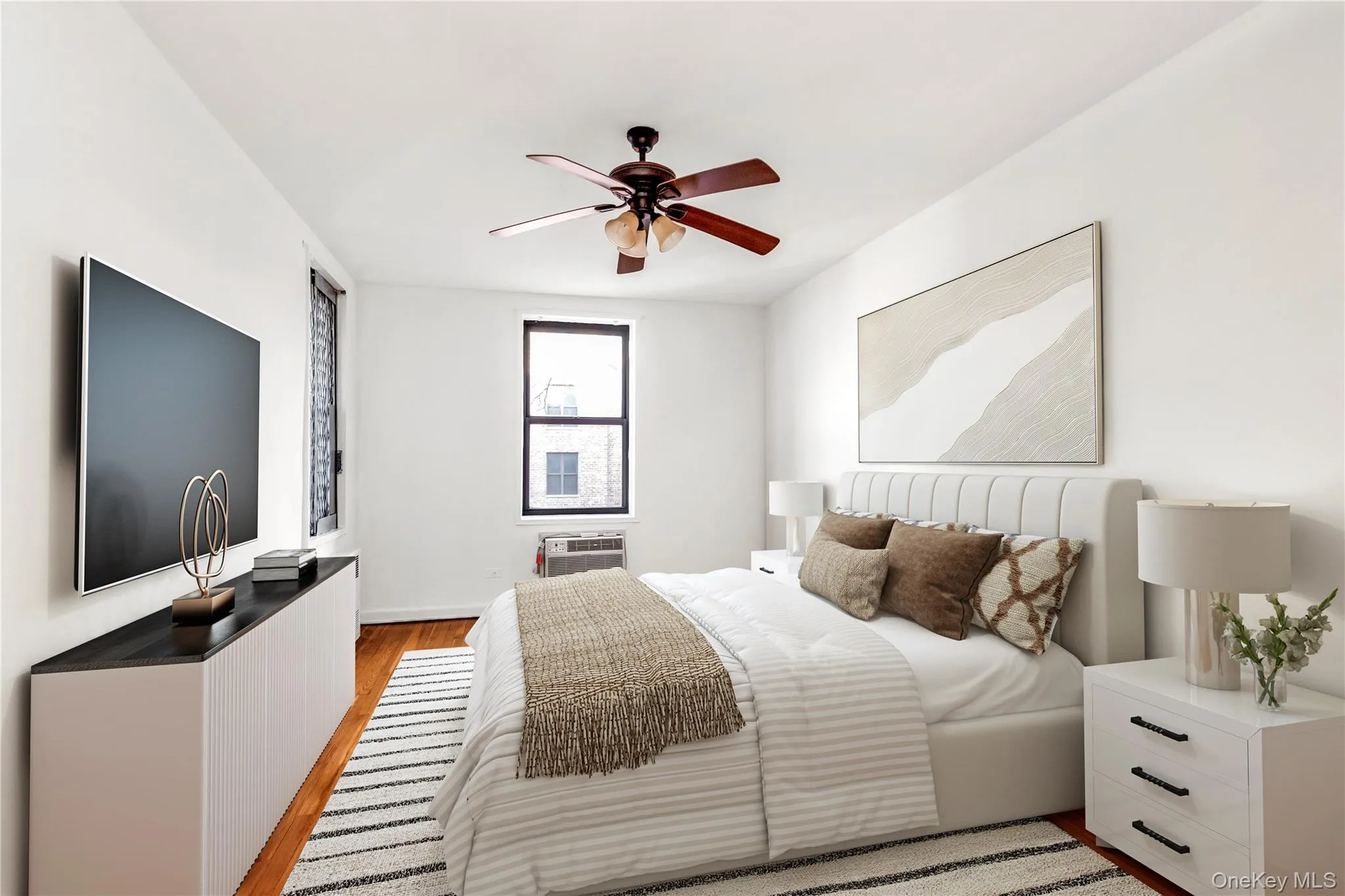 Bedroom with light wood finished floors and ceiling fan Bedroom with light wood finished floors and ceiling fan