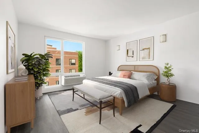 Bedroom with wood finished floors and a wall mounted AC Bedroom with wood finished floors and a wall mounted AC
