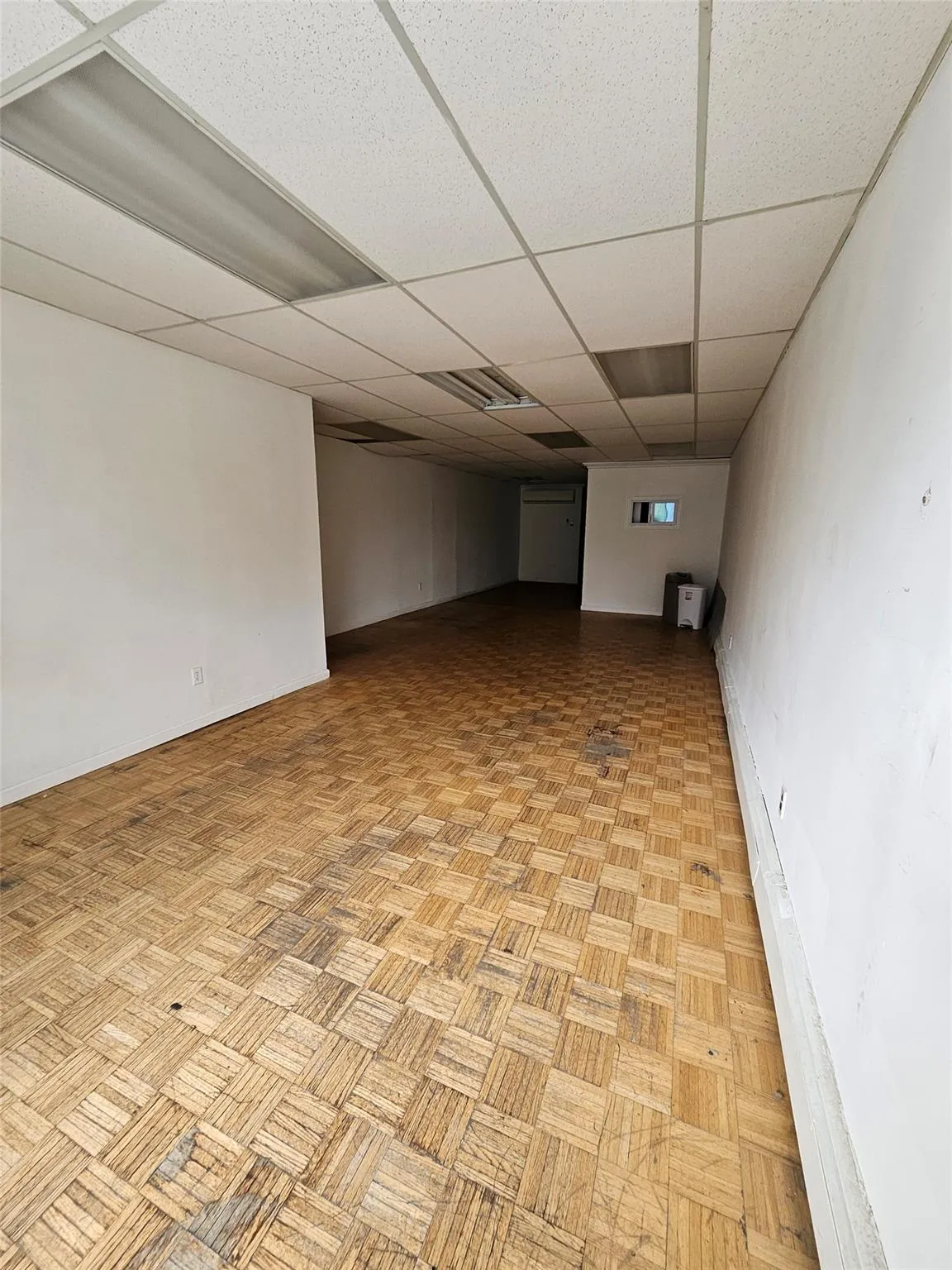 Finished basement with a paneled ceiling and baseboards Finished basement with a paneled ceiling and baseboards