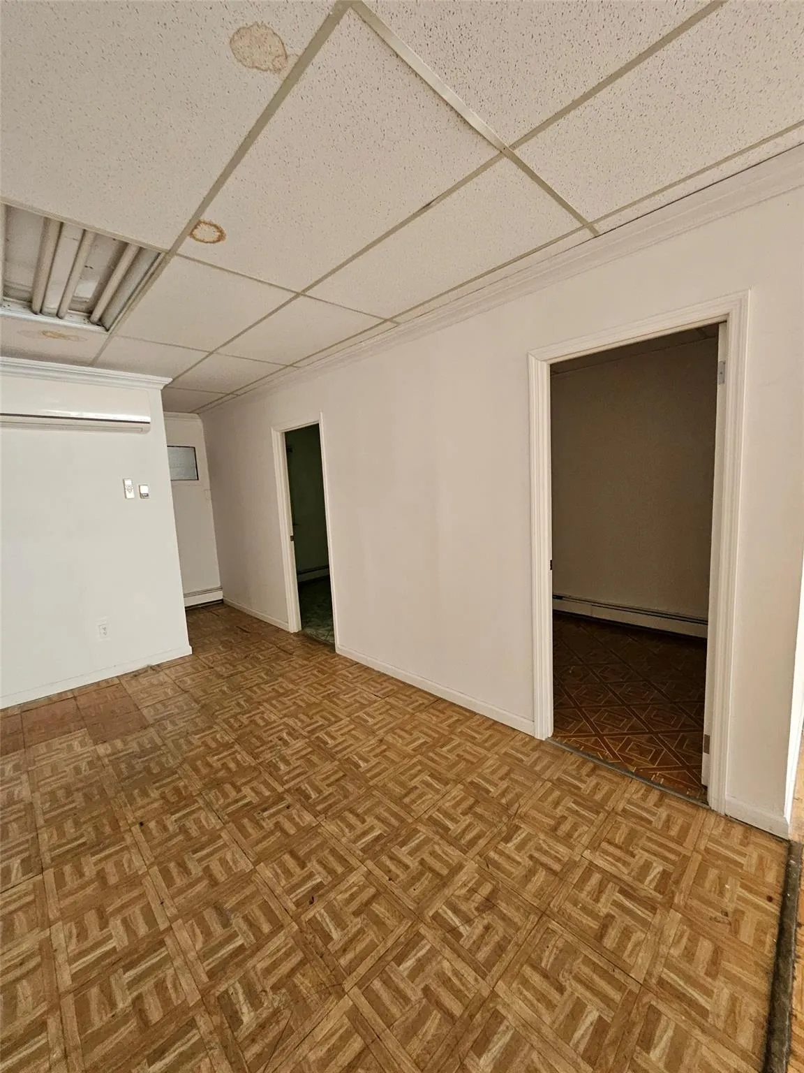 Spare room with a drop ceiling and a baseboard radiator Spare room with a drop ceiling and a baseboard radiator