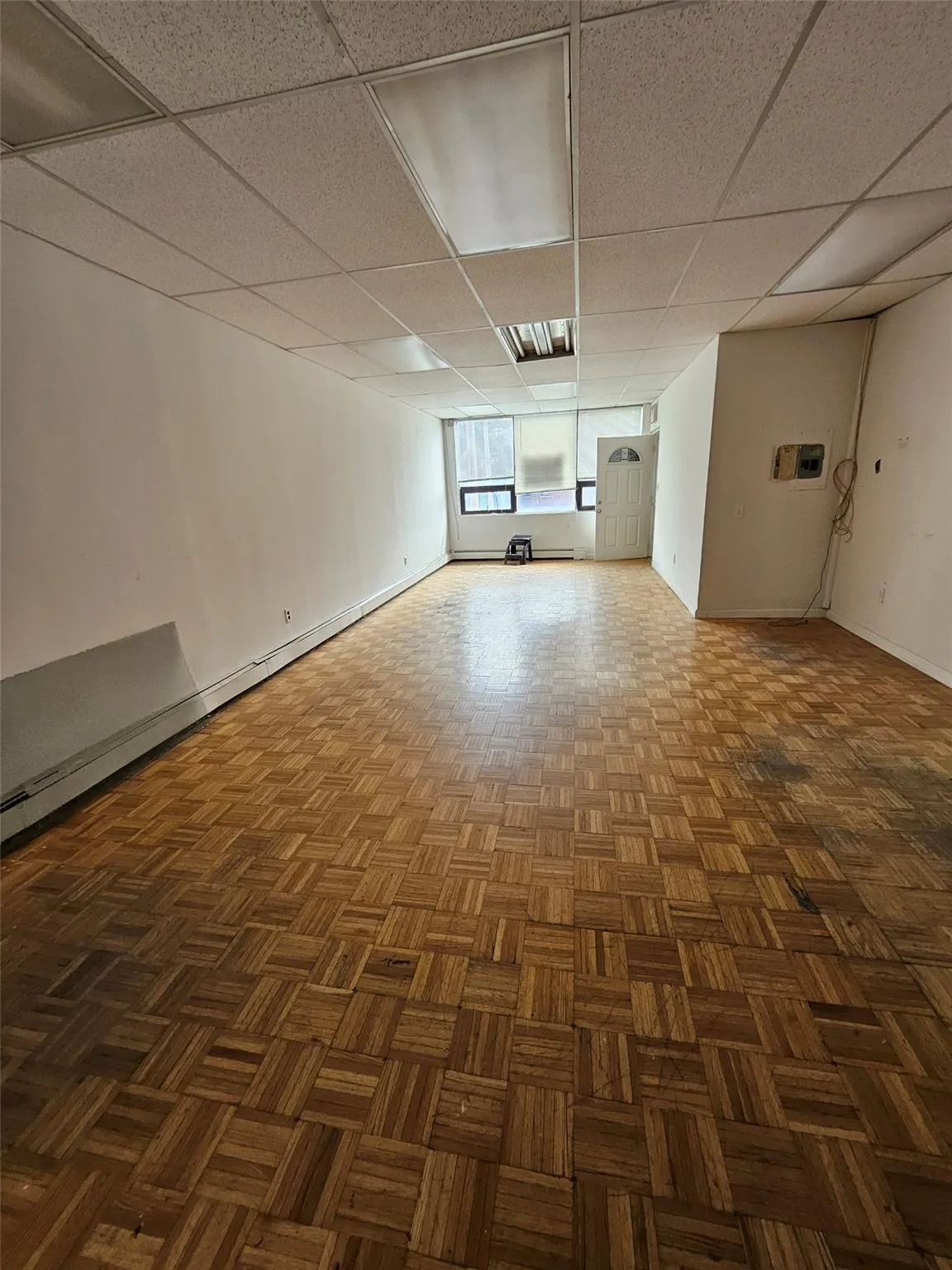 Spare room featuring a baseboard heating unit and a drop ceiling Spare room featuring a baseboard heating unit and a drop ceiling
