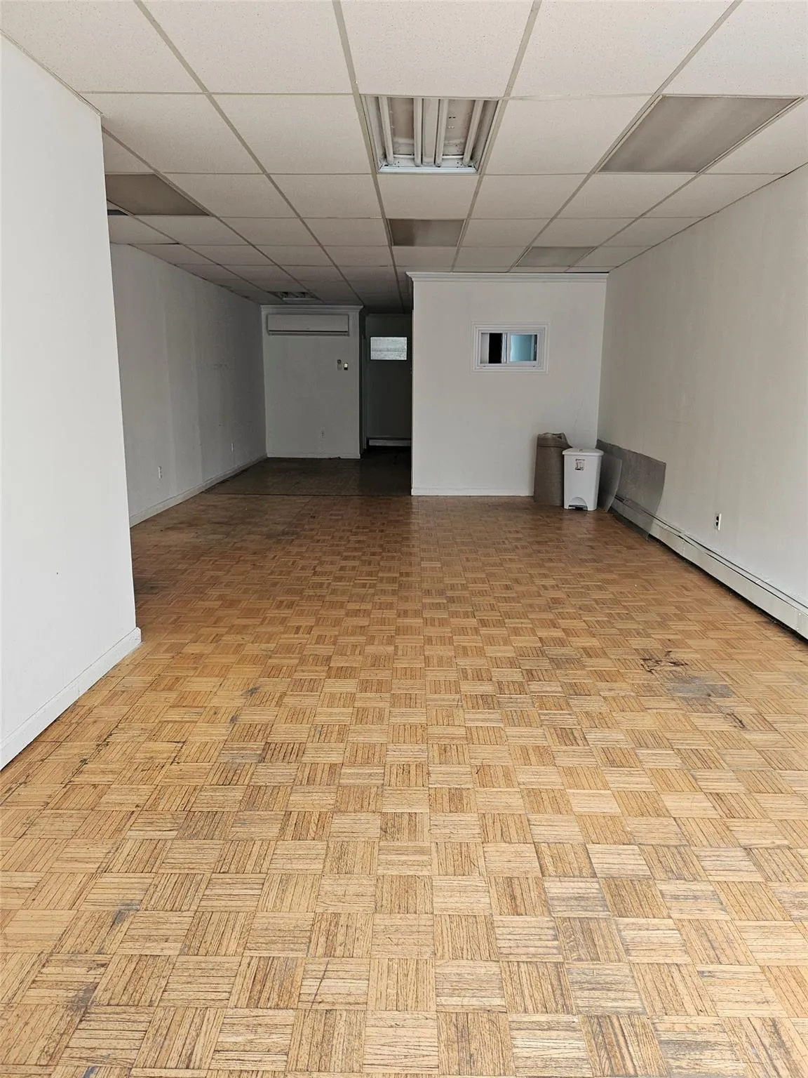 Finished basement with baseboard heating and a paneled ceiling Finished basement with baseboard heating and a paneled ceiling