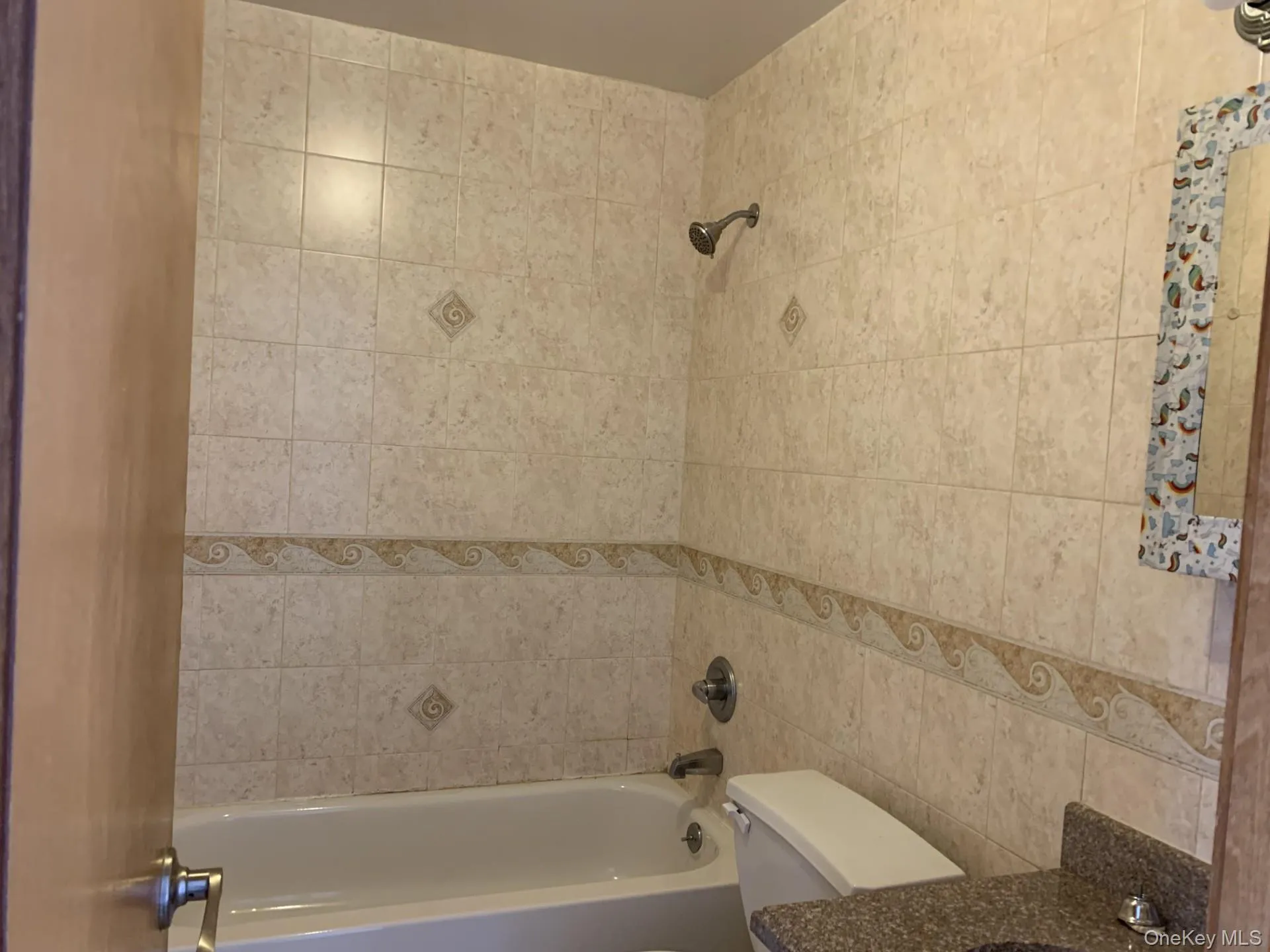 Full bathroom featuring tub / shower combination, tile walls, and vanity Full bathroom featuring tub / shower combination, tile walls, and vanity