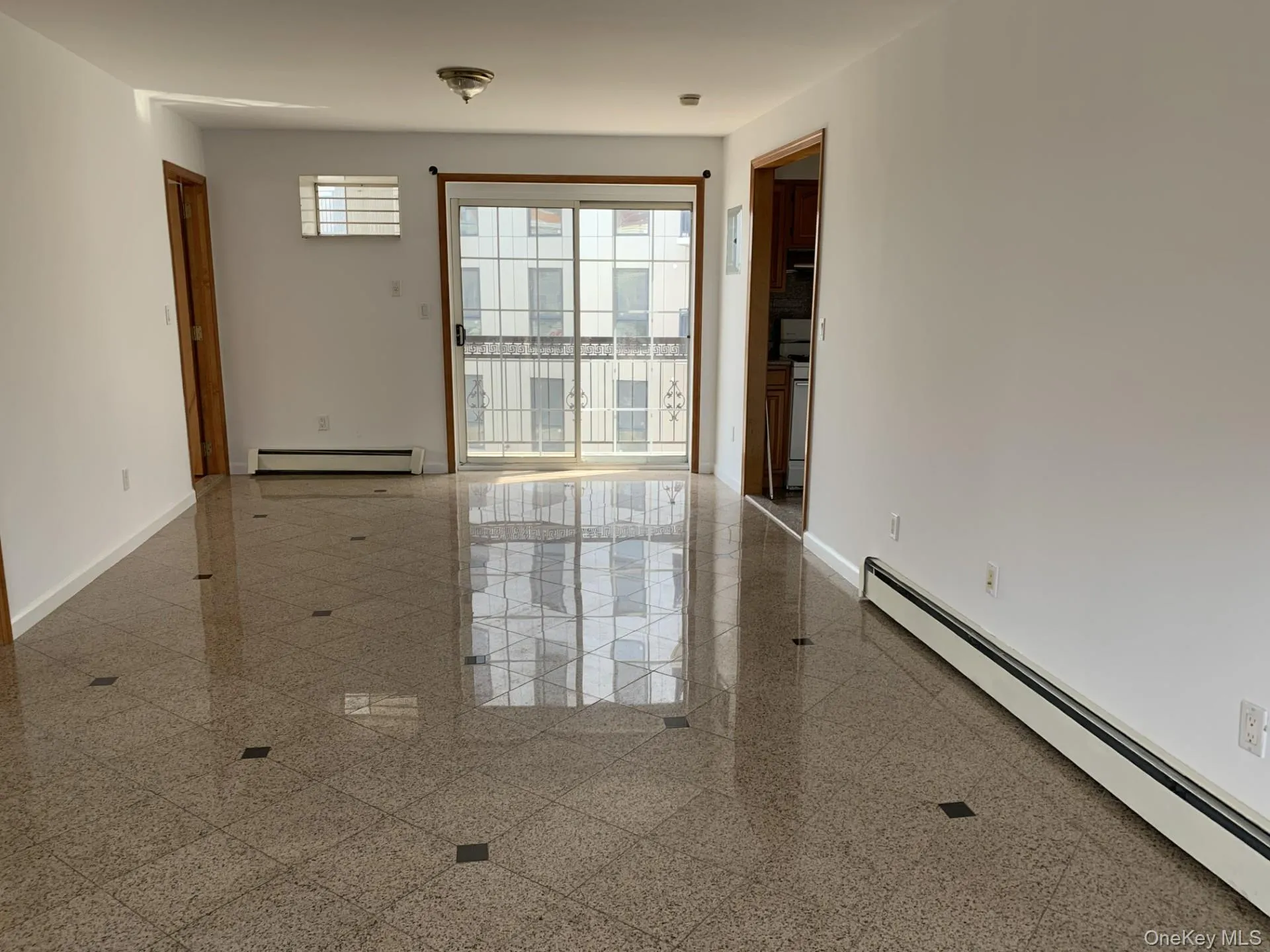 Empty room with baseboard heating and granite floors Empty room with baseboard heating and granite floors