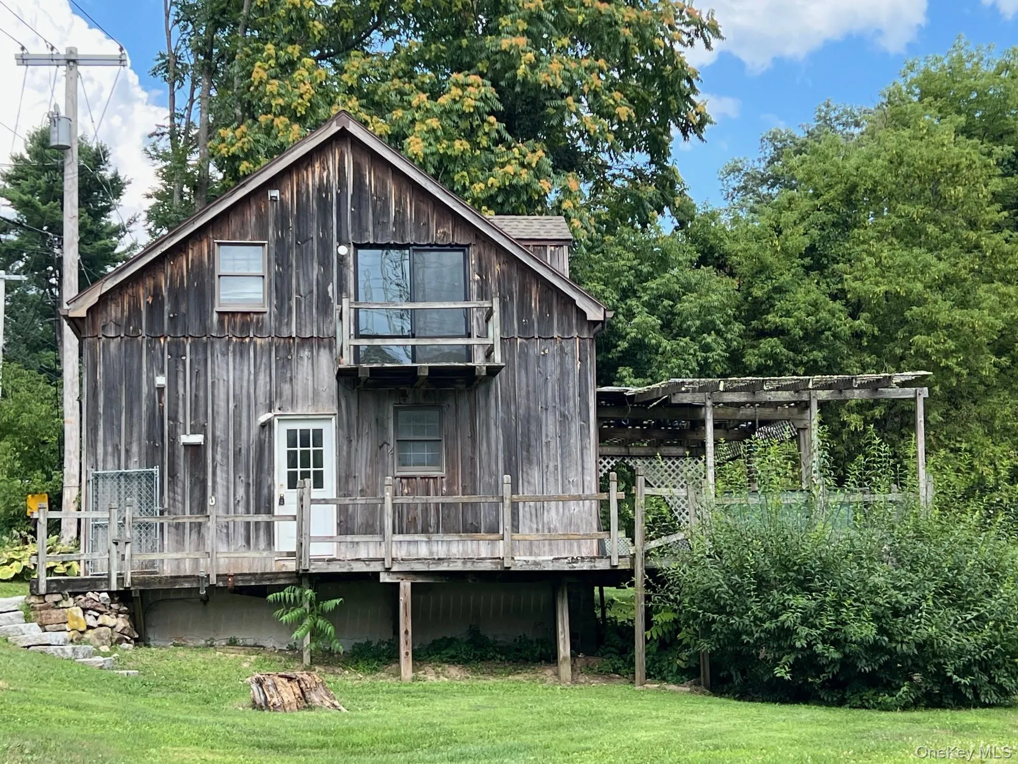 Rear view of house with a yard, a deck, and a pergola Rear view of house with a yard, a deck, and a pergola