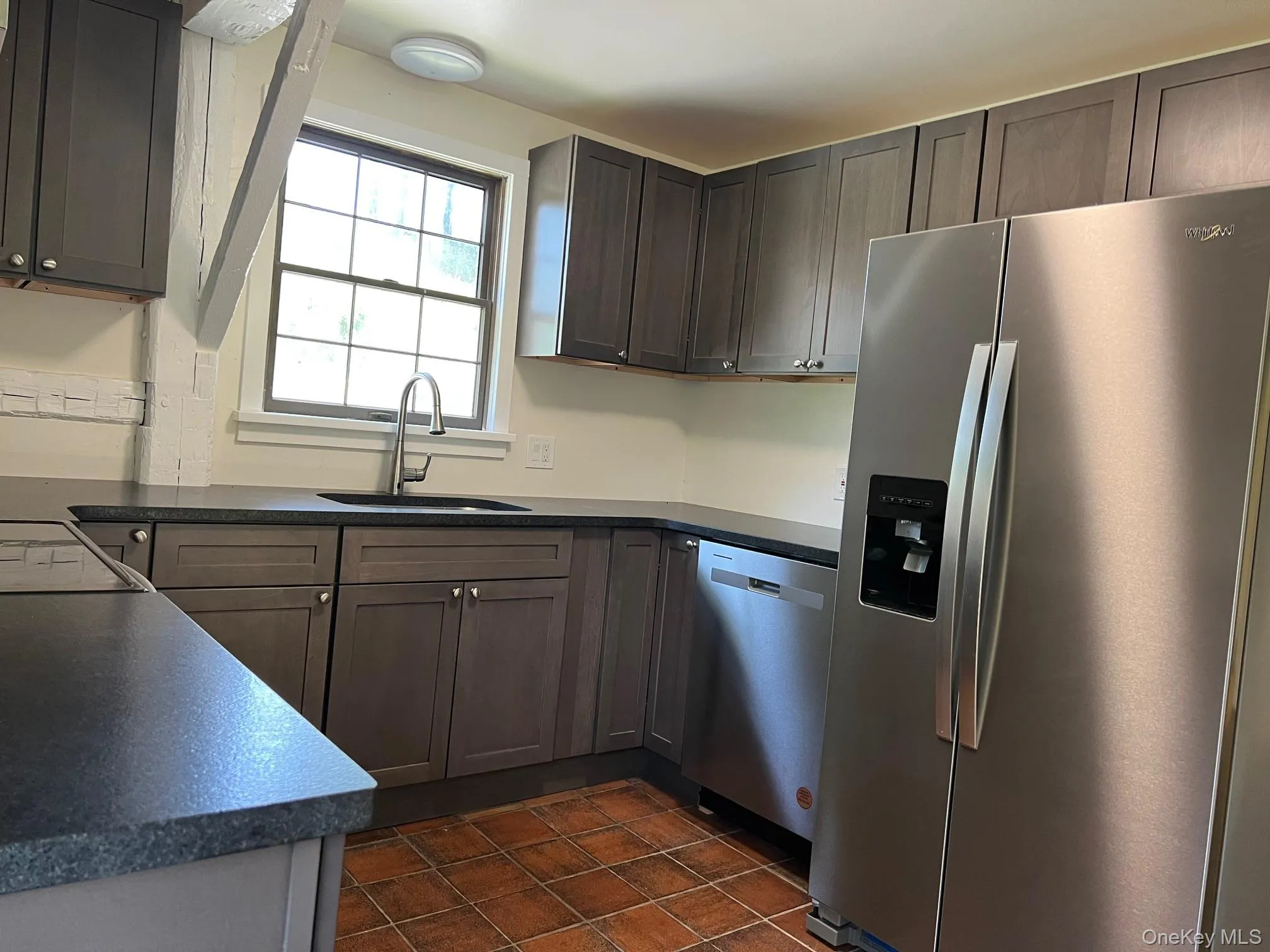 Brand new Kitchen featuring appliances with stainless steel finishes, dark countertops, and dark tile patterned floors Brand new Kitchen featuring appliances with stainless steel finishes, dark countertops, and dark tile patterned floors