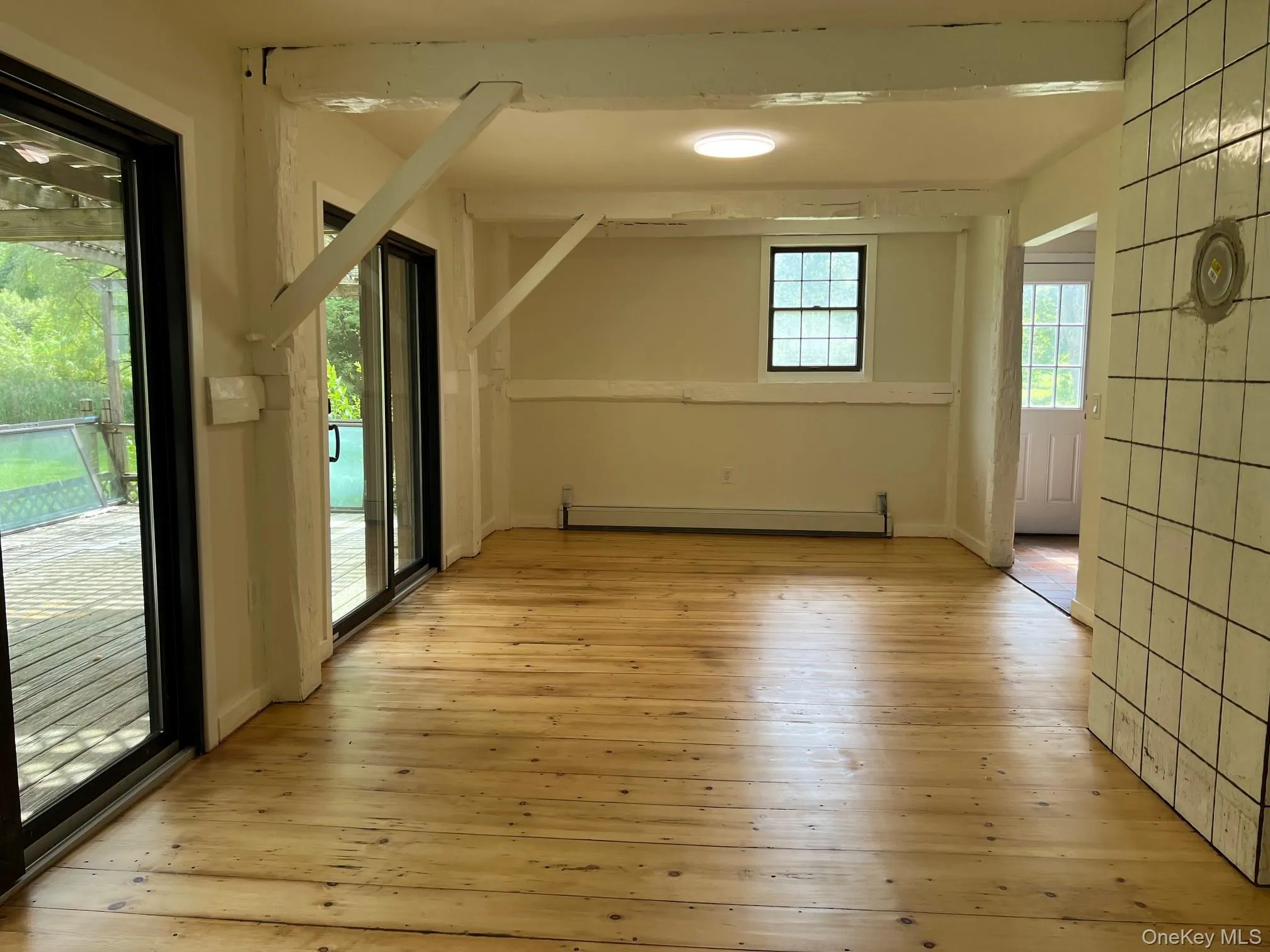 Additional living space with light wood-type flooring and baseboard heating Additional living space with light wood-type flooring and baseboard heating