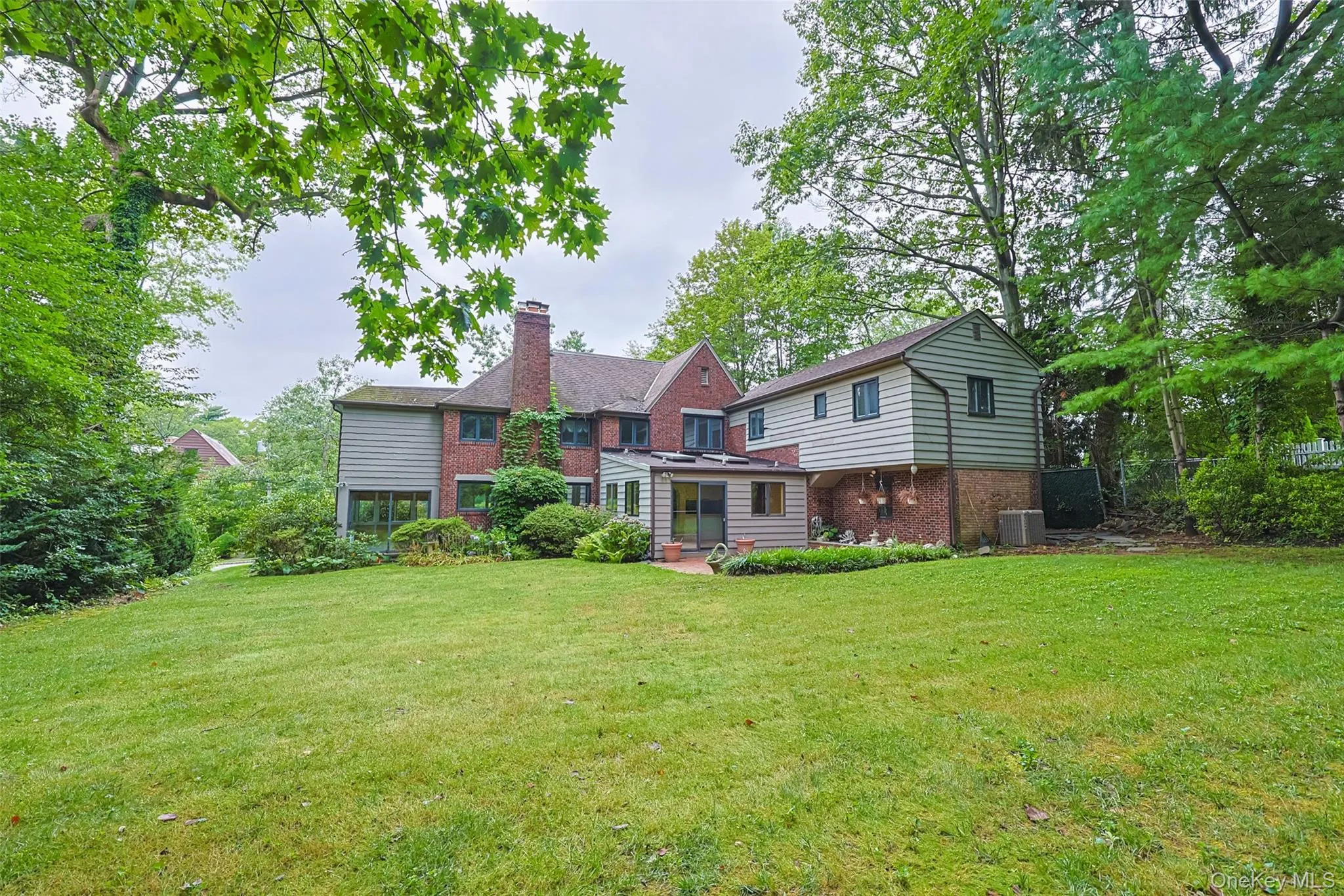 Back of house featuring brick siding and a chimney Back of house featuring brick siding and a chimney