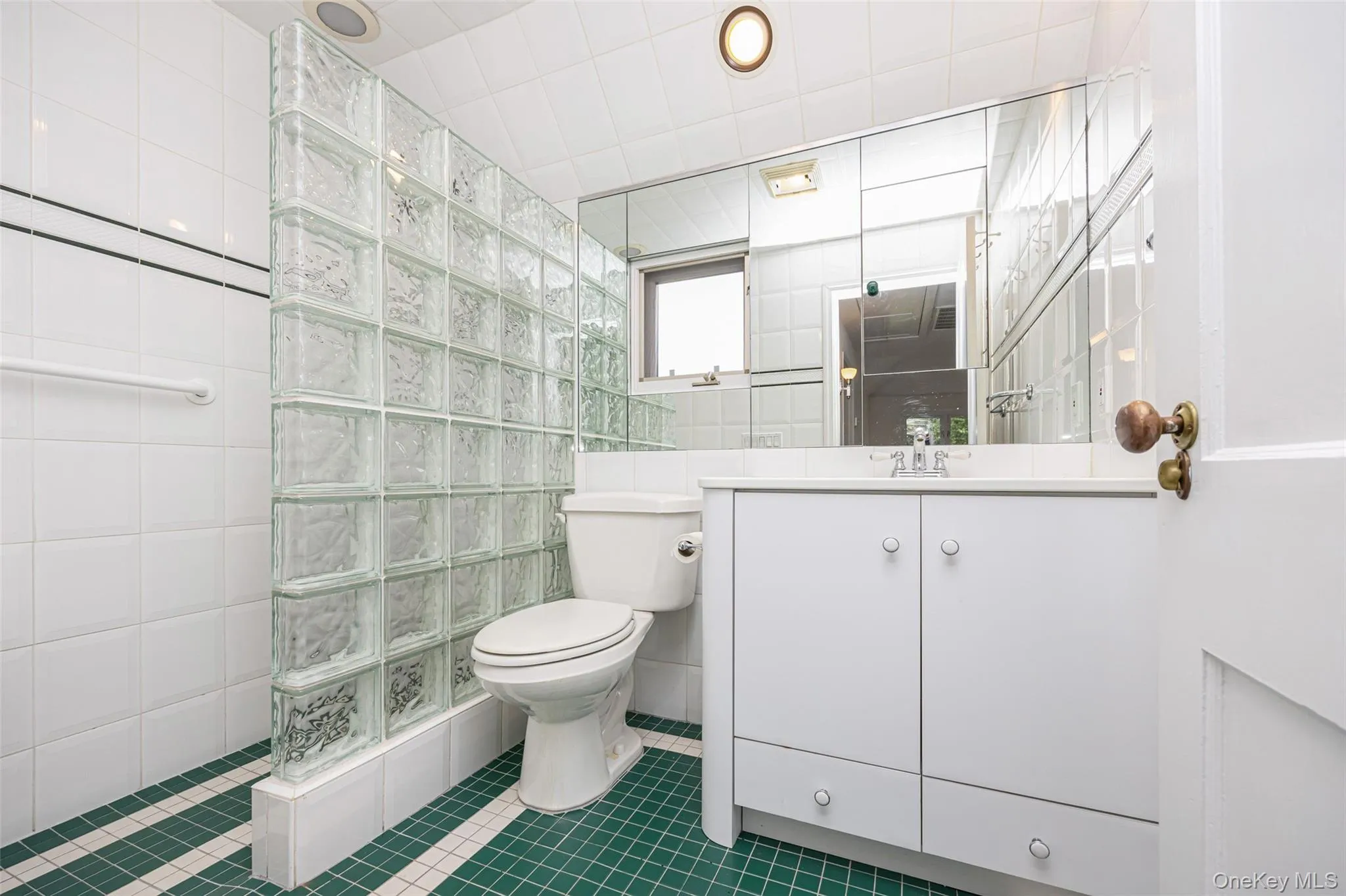 Bathroom with tile walls, walk in shower, vanity, and tile patterned flooring Bathroom with tile walls, walk in shower, vanity, and tile patterned flooring