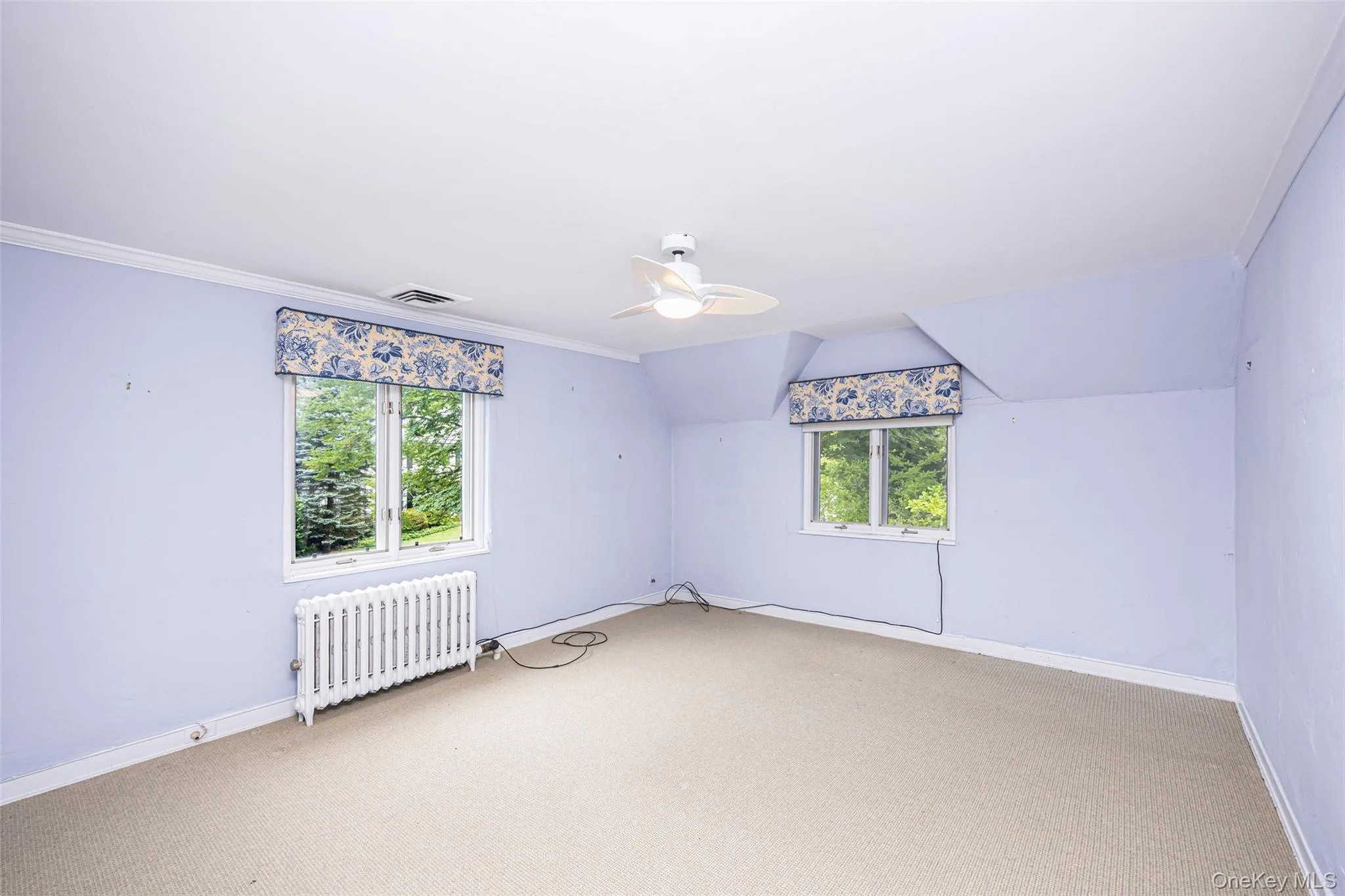 Bonus room with carpet floors, radiator heating unit, and ceiling fan Bonus room with carpet floors, radiator heating unit, and ceiling fan