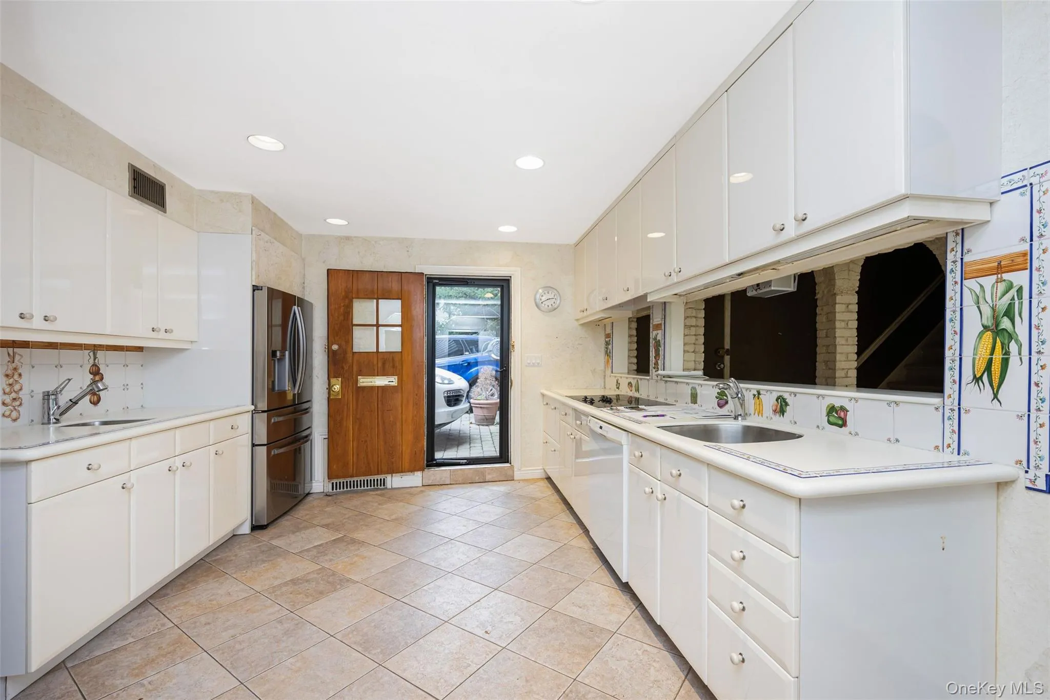 Kitchen featuring light countertops, stainless steel refrigerator with ice dispenser, white cabinets, dishwasher, and recessed lighting Kitchen featuring light countertops, stainless steel refrigerator with ice dispenser, white cabinets, dishwasher, and recessed lighting