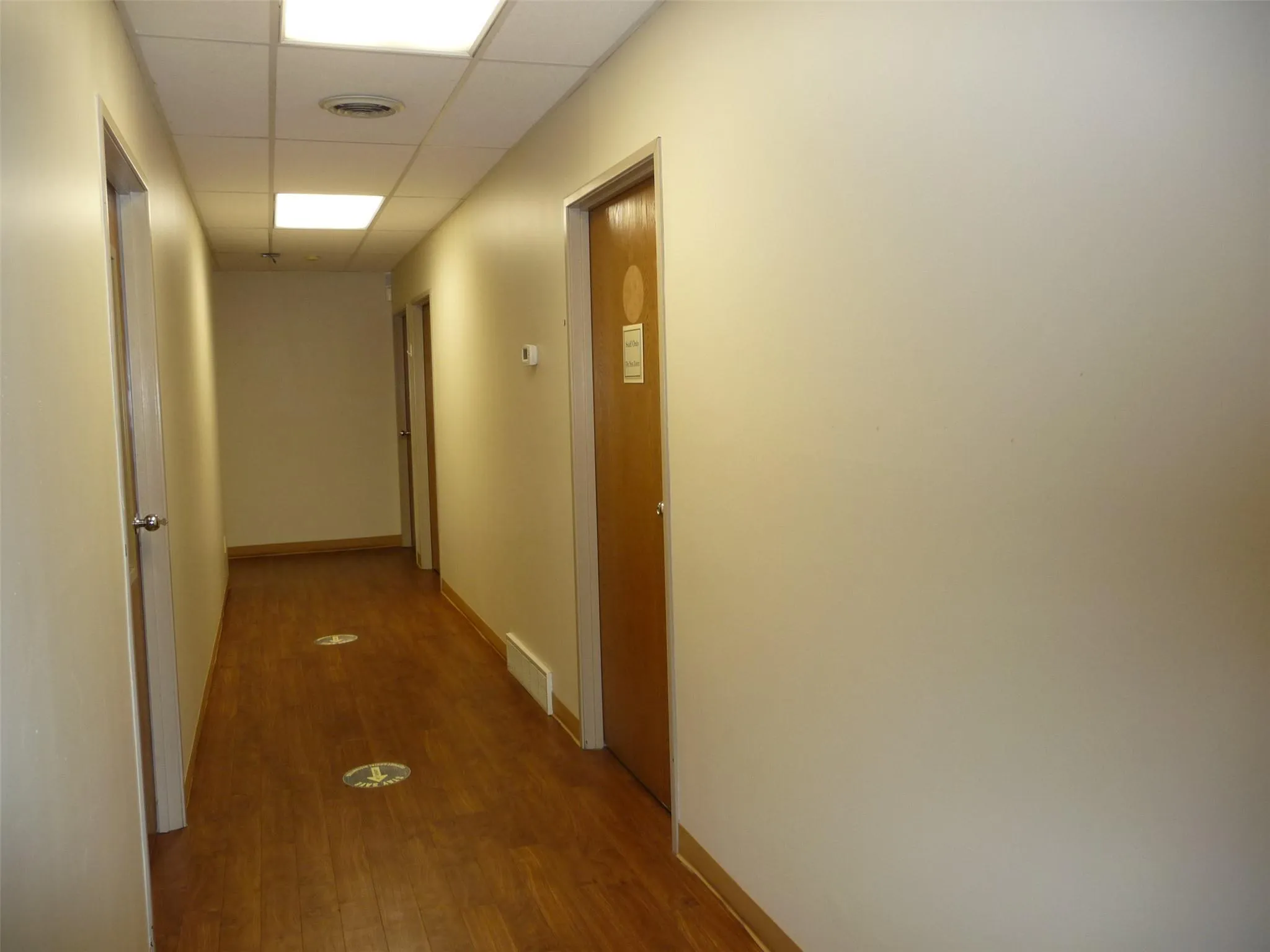 Hall with a paneled ceiling and wood finished floors Hall with a paneled ceiling and wood finished floors