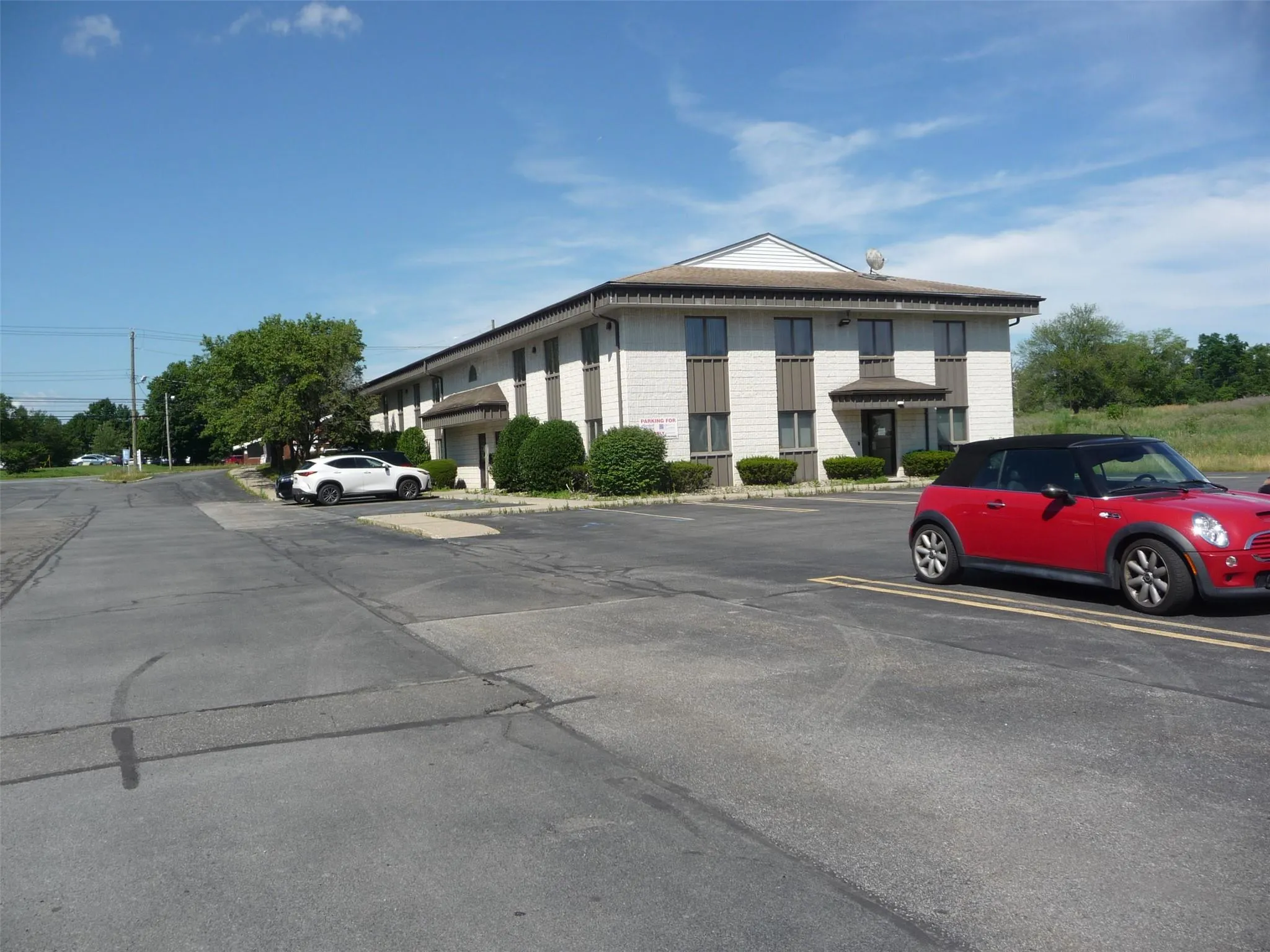 View of property with uncovered parking View of property with uncovered parking