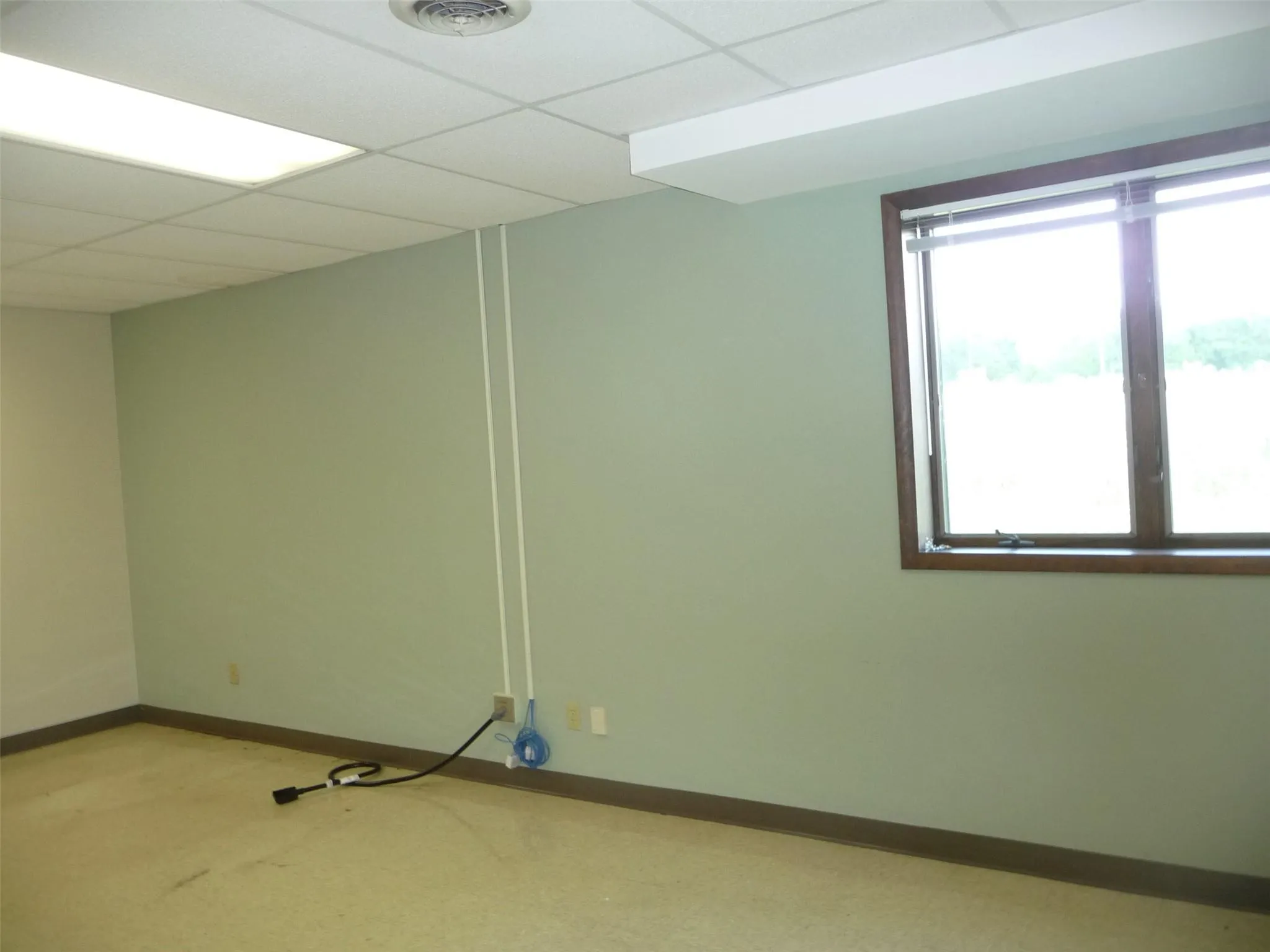 Empty room with baseboards and a drop ceiling Empty room with baseboards and a drop ceiling