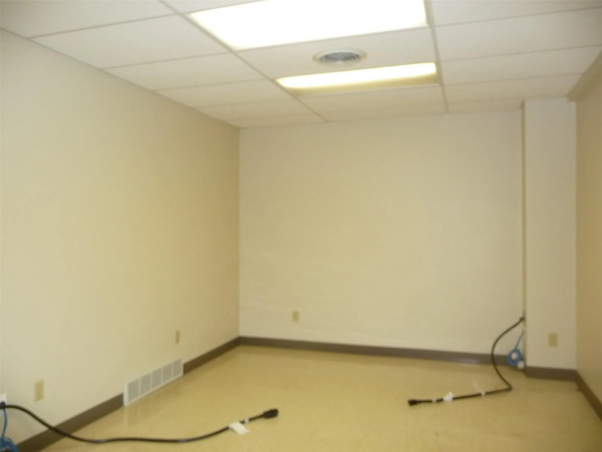 Below grade area with a drop ceiling and baseboards Below grade area with a drop ceiling and baseboards