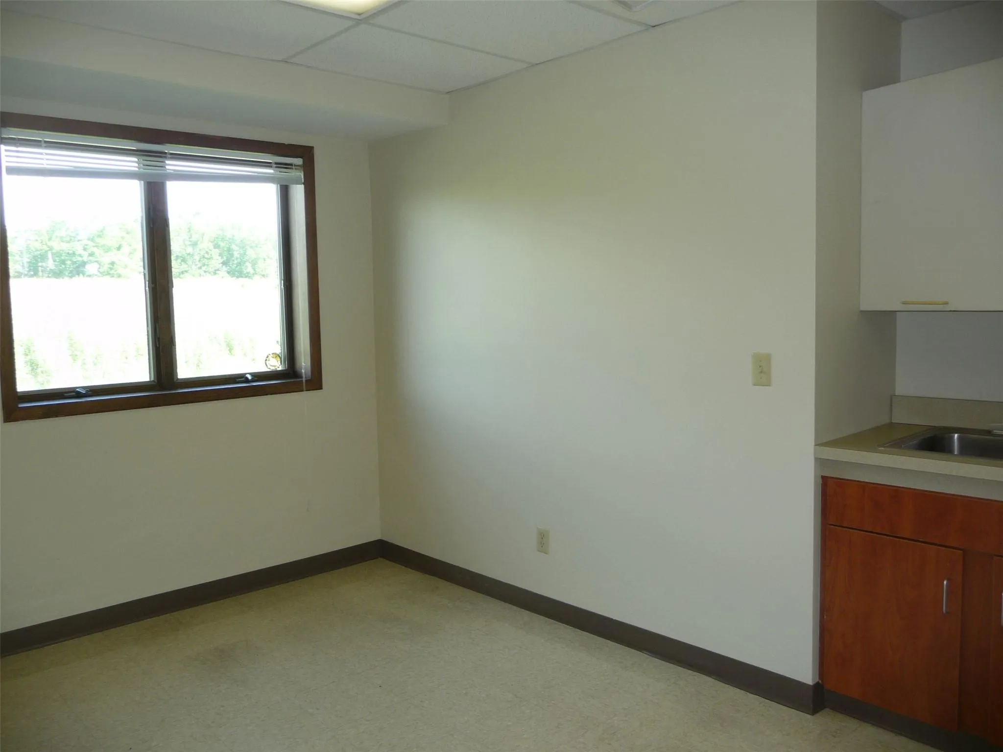 Spare room featuring a paneled ceiling and baseboards Spare room featuring a paneled ceiling and baseboards