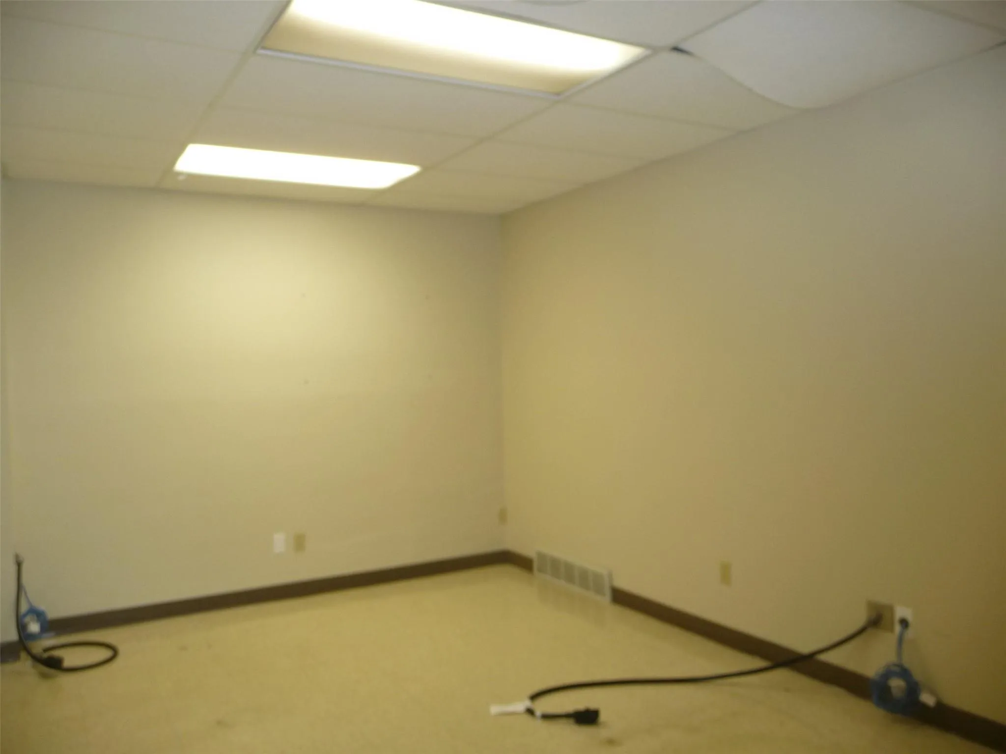 Empty room with a paneled ceiling and baseboards Empty room with a paneled ceiling and baseboards