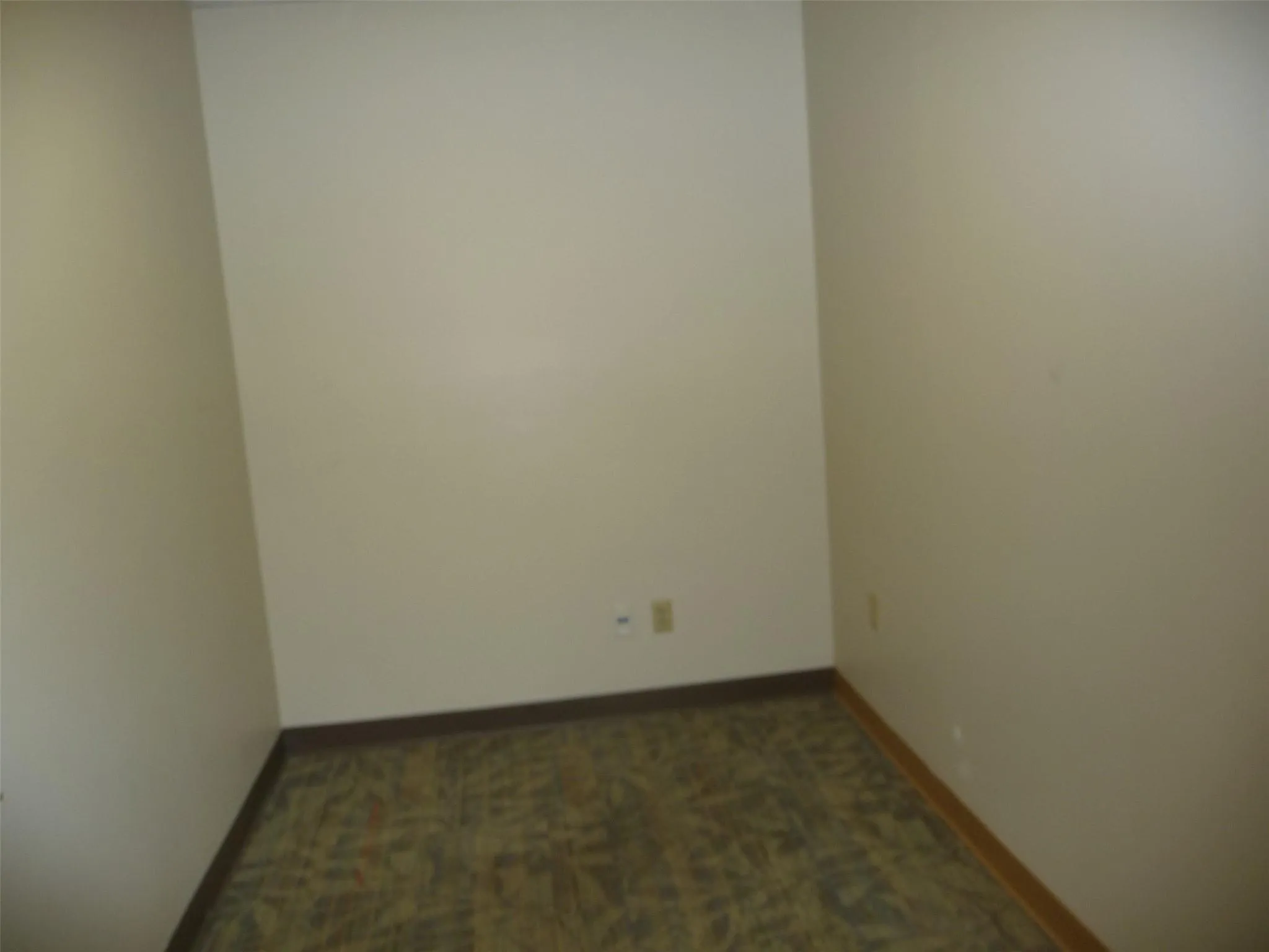 Unfurnished room featuring dark carpet and baseboards Unfurnished room featuring dark carpet and baseboards