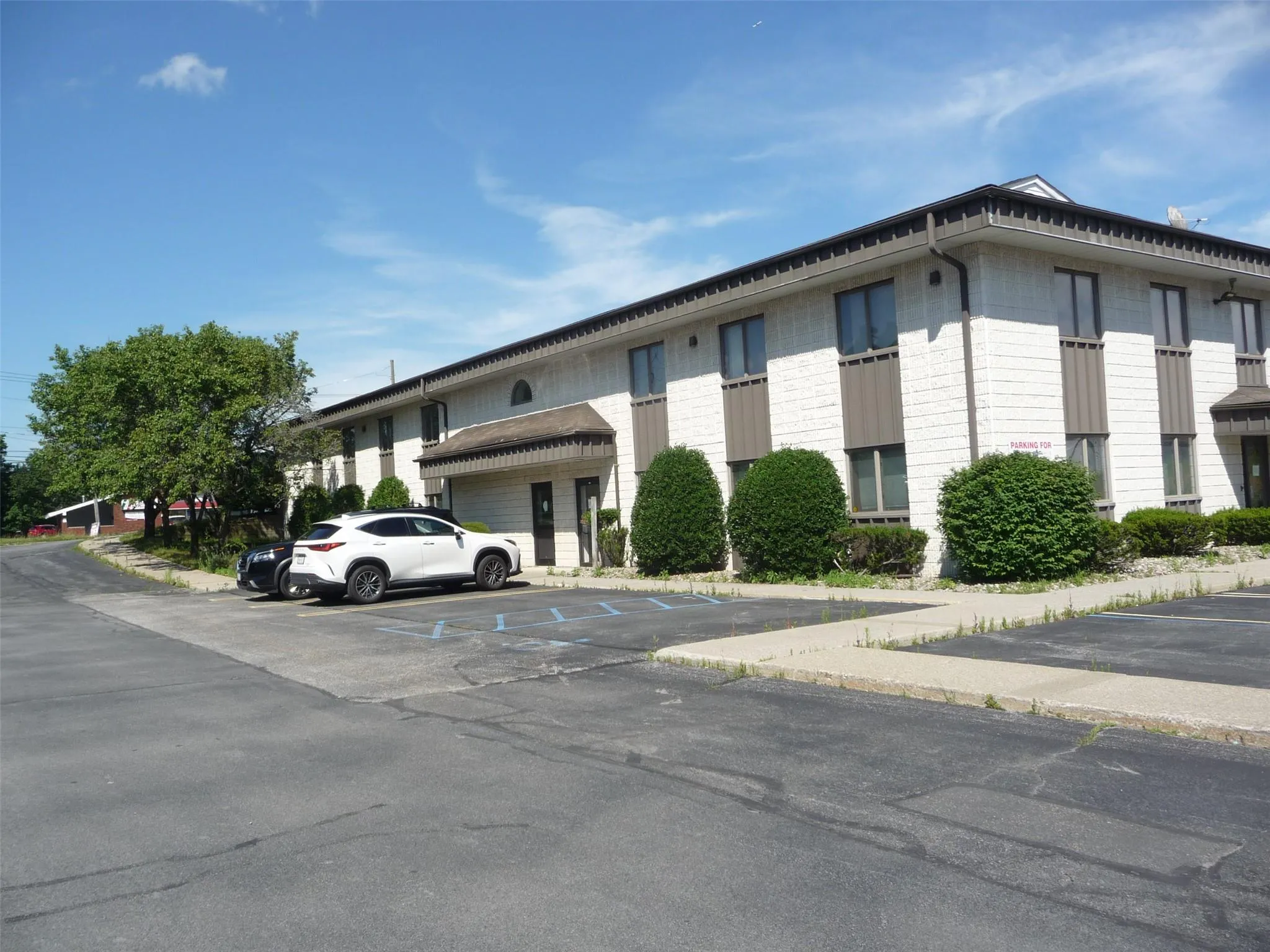 View of building exterior featuring uncovered parking View of building exterior featuring uncovered parking