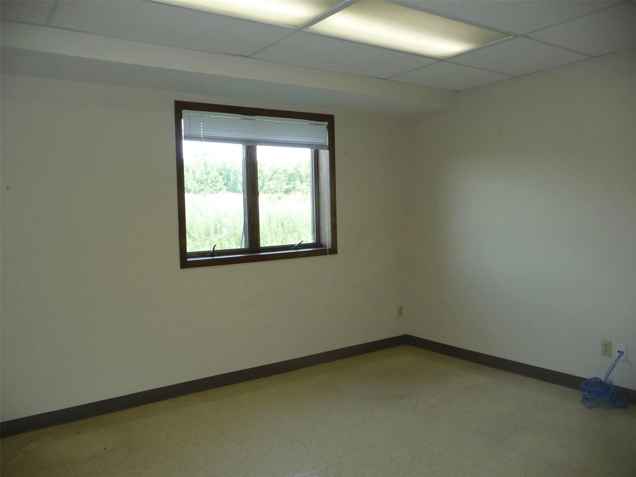Empty room featuring baseboards and a drop ceiling Empty room featuring baseboards and a drop ceiling