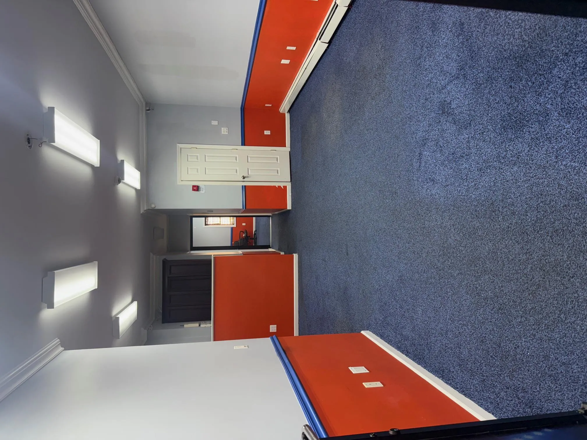 Empty room with baseboard heating, ornamental molding, and dark colored carpet Empty room with baseboard heating, ornamental molding, and dark colored carpet