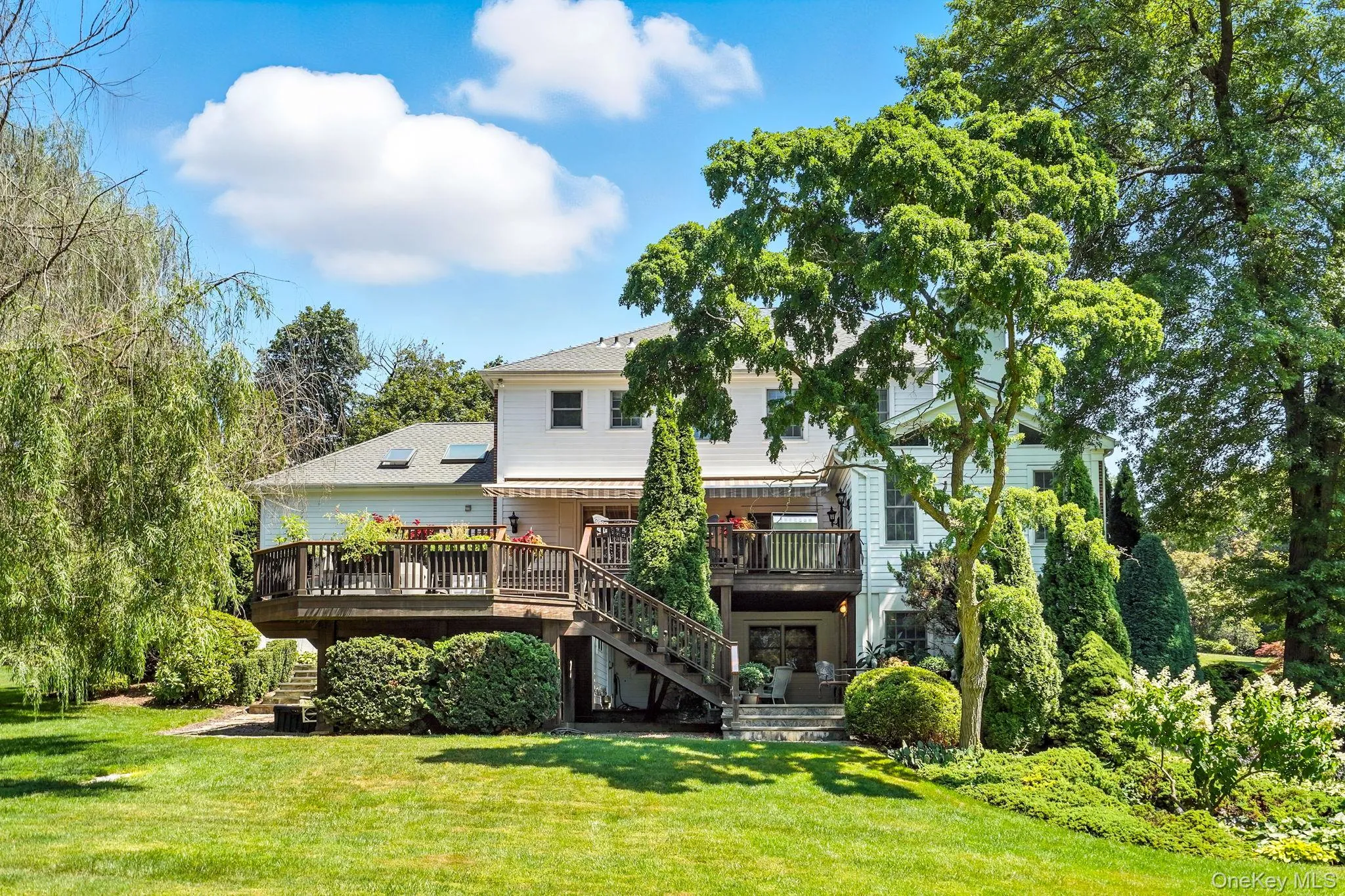 Rear view of house featuring a deck, stairway, and a yard Rear view of house featuring a deck, stairway, and a yard