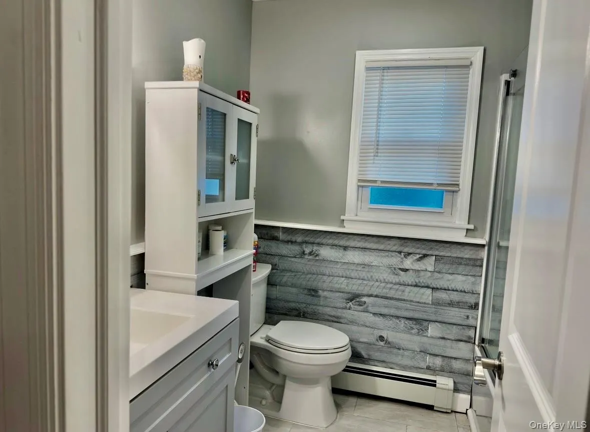 Bathroom featuring vanity and a baseboard heating unit Bathroom featuring vanity and a baseboard heating unit
