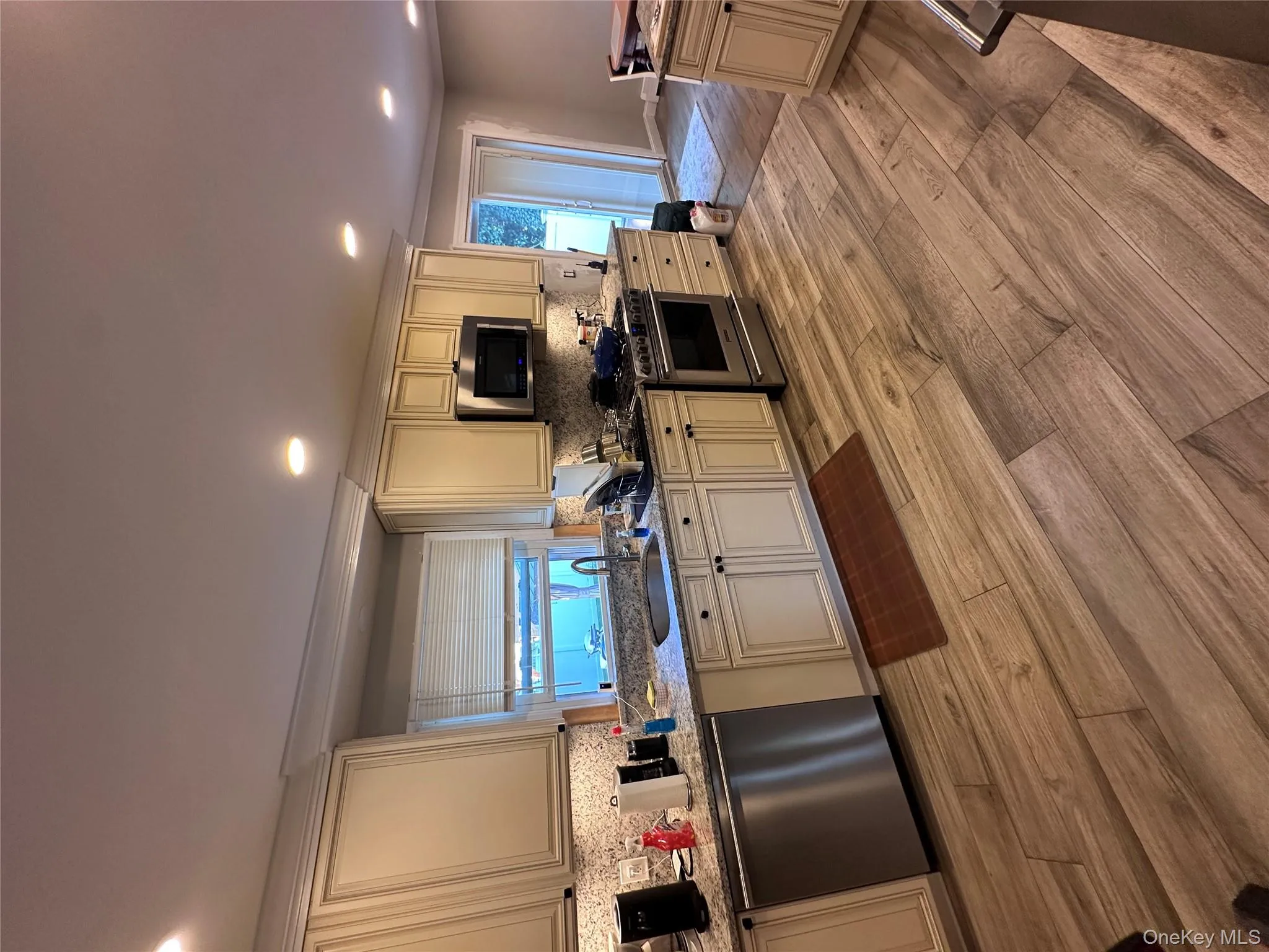 Kitchen with cream cabinets, dishwasher, light wood-style flooring, recessed lighting, and ornamental molding Kitchen with cream cabinets, dishwasher, light wood-style flooring, recessed lighting, and ornamental molding